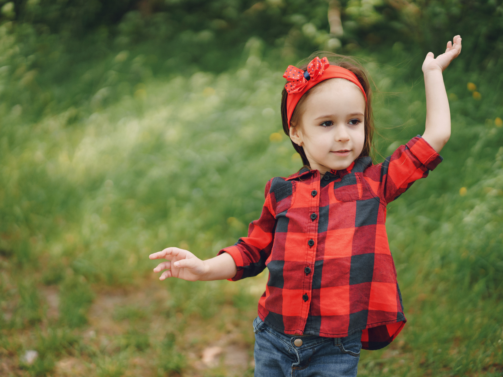 Милая девочка с красным бантом на голове 