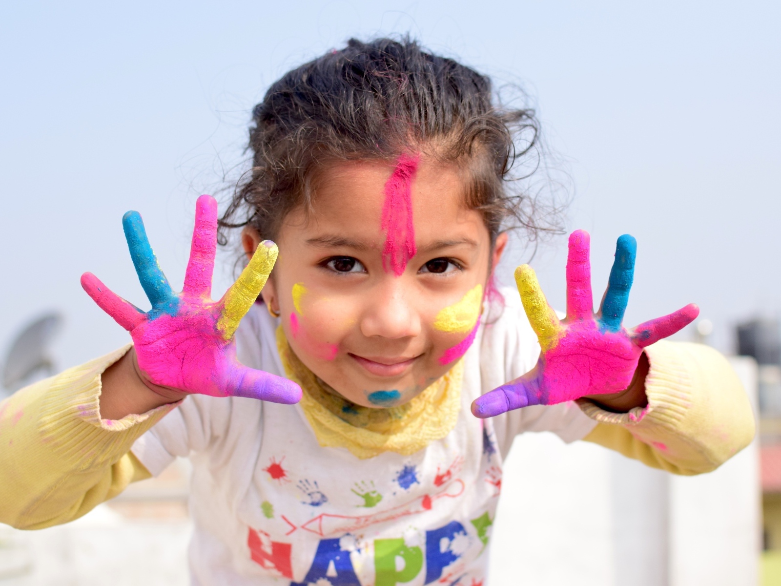 Девочка с руками в краске на празднике