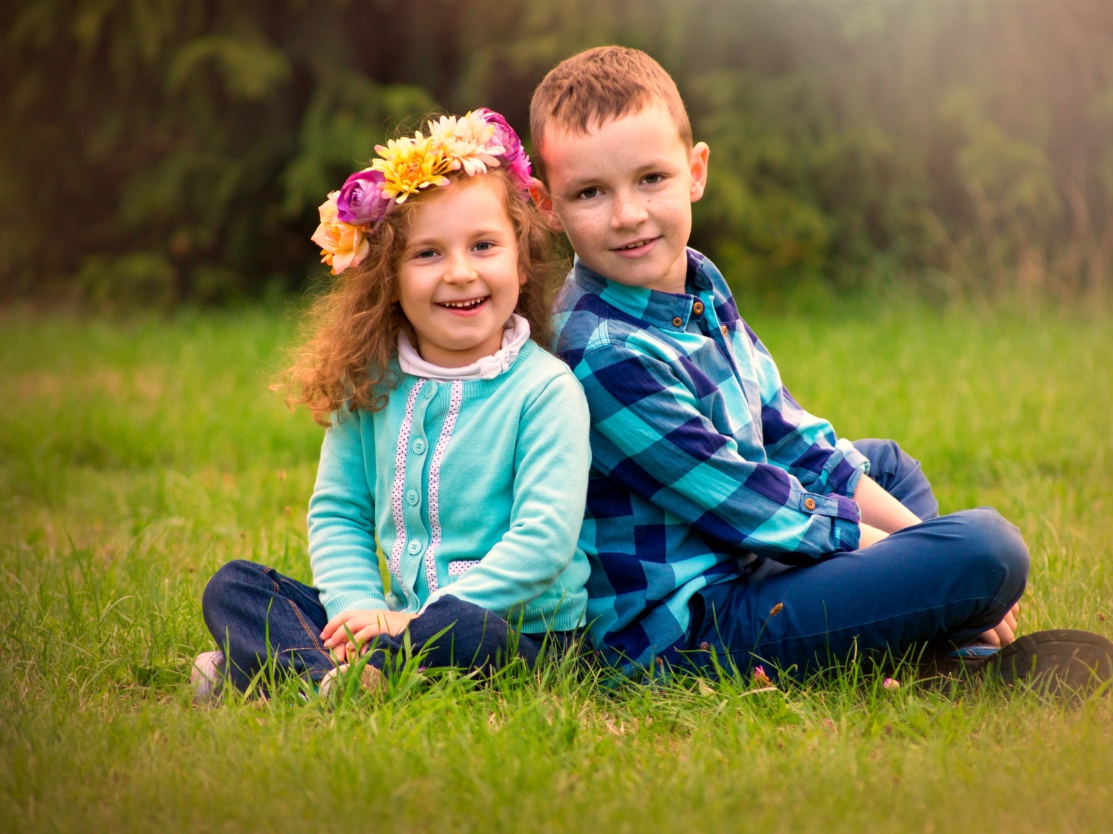 Рыжеволосые мальчик и девочка сидят на траве