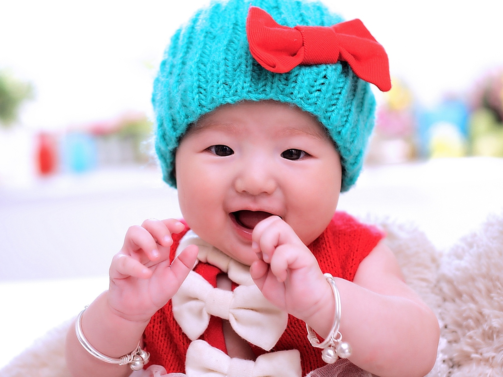 Улыбающаяся девочка в зеленой вязаной шапке