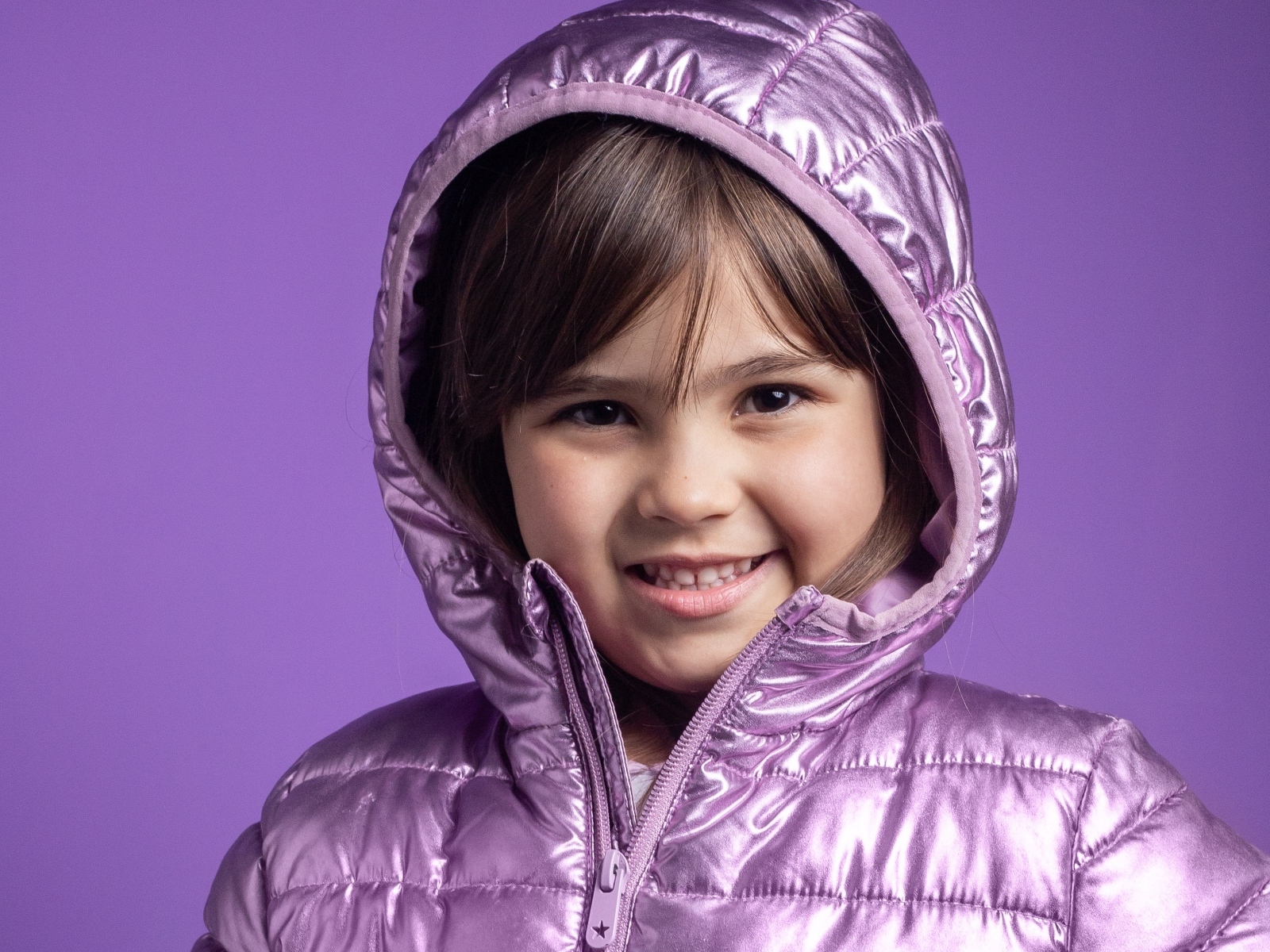 Улыбающаяся девочка в сиреневой куртке