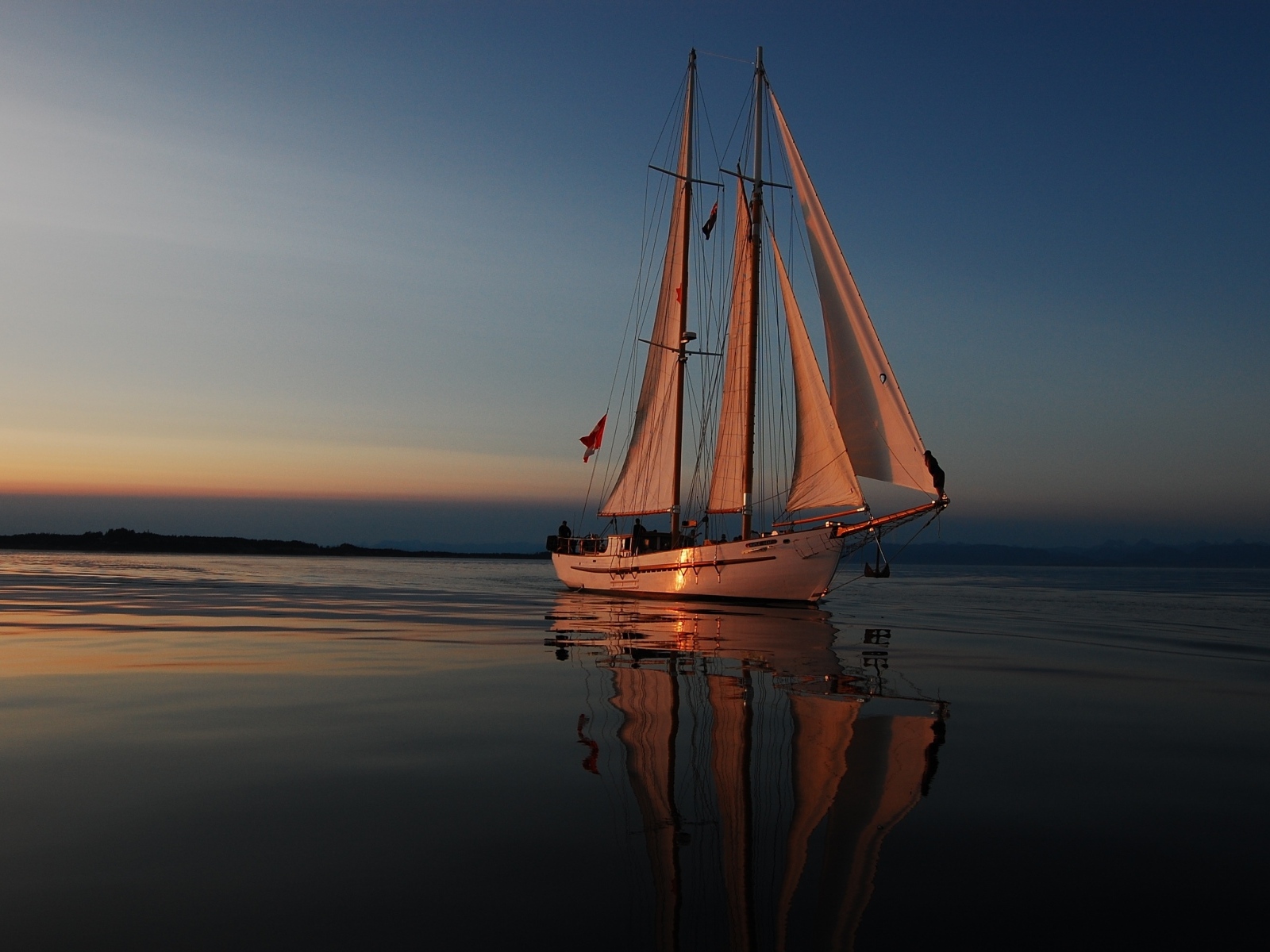 Большая парусная яхта в море на закате