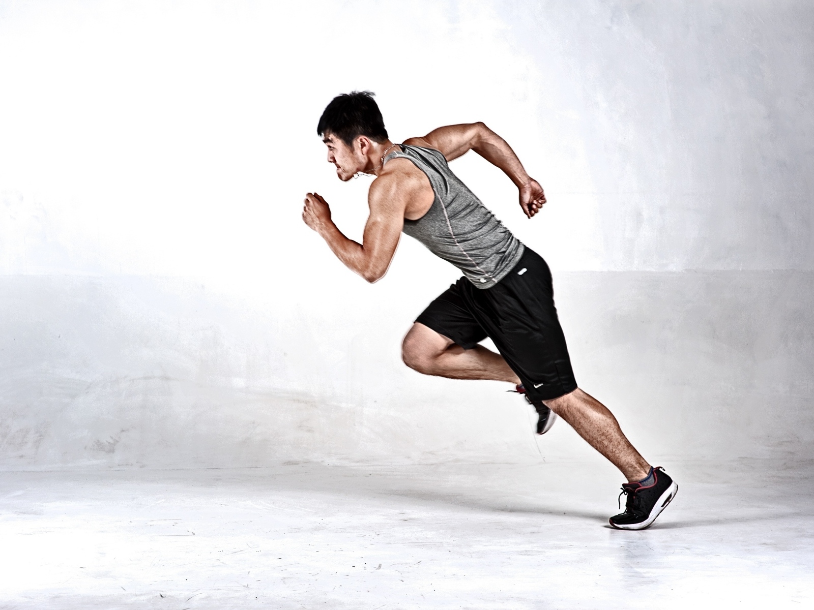 Мужчина бегун на сером фоне