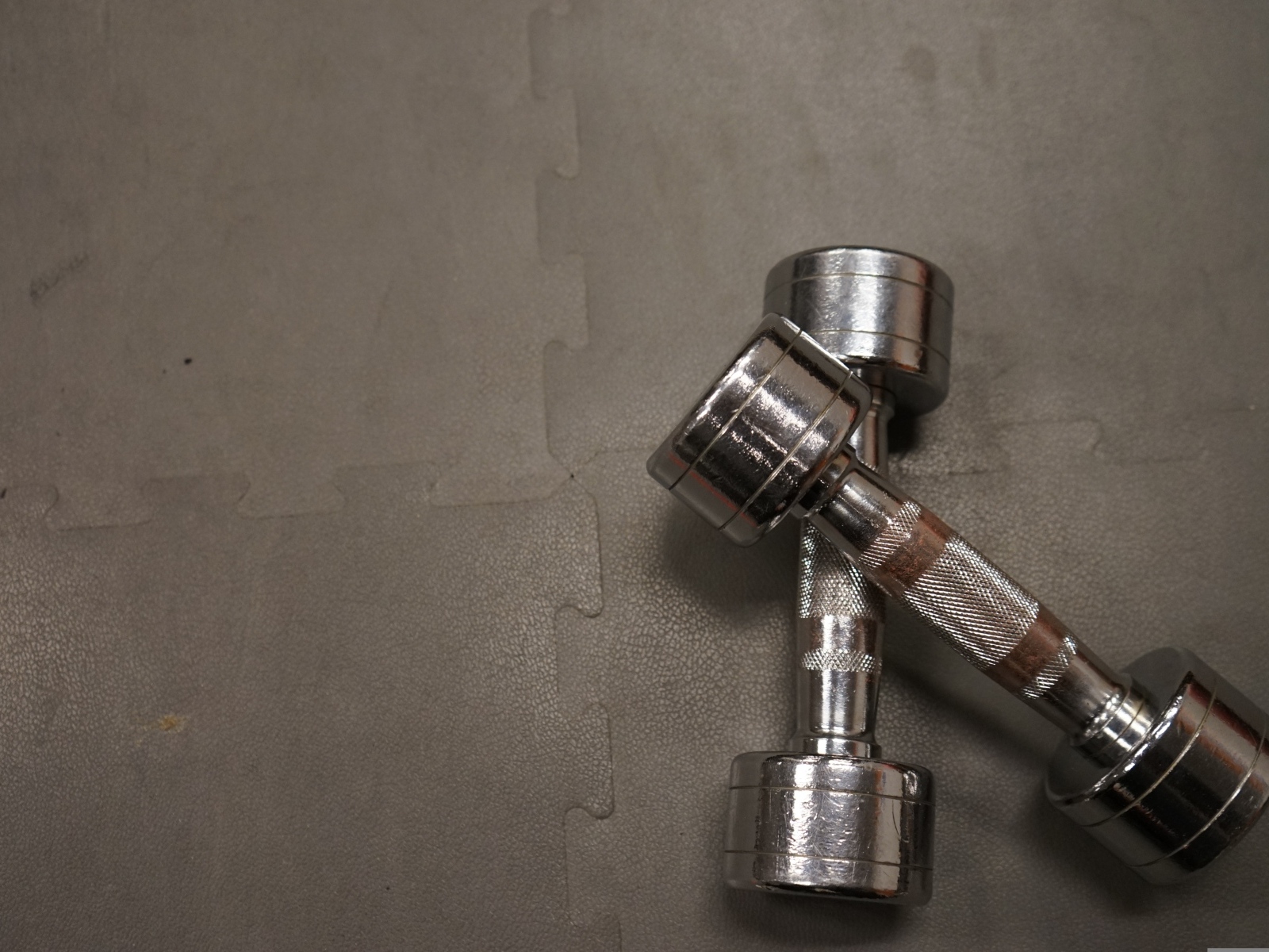 Две железные гантели на сером фоне