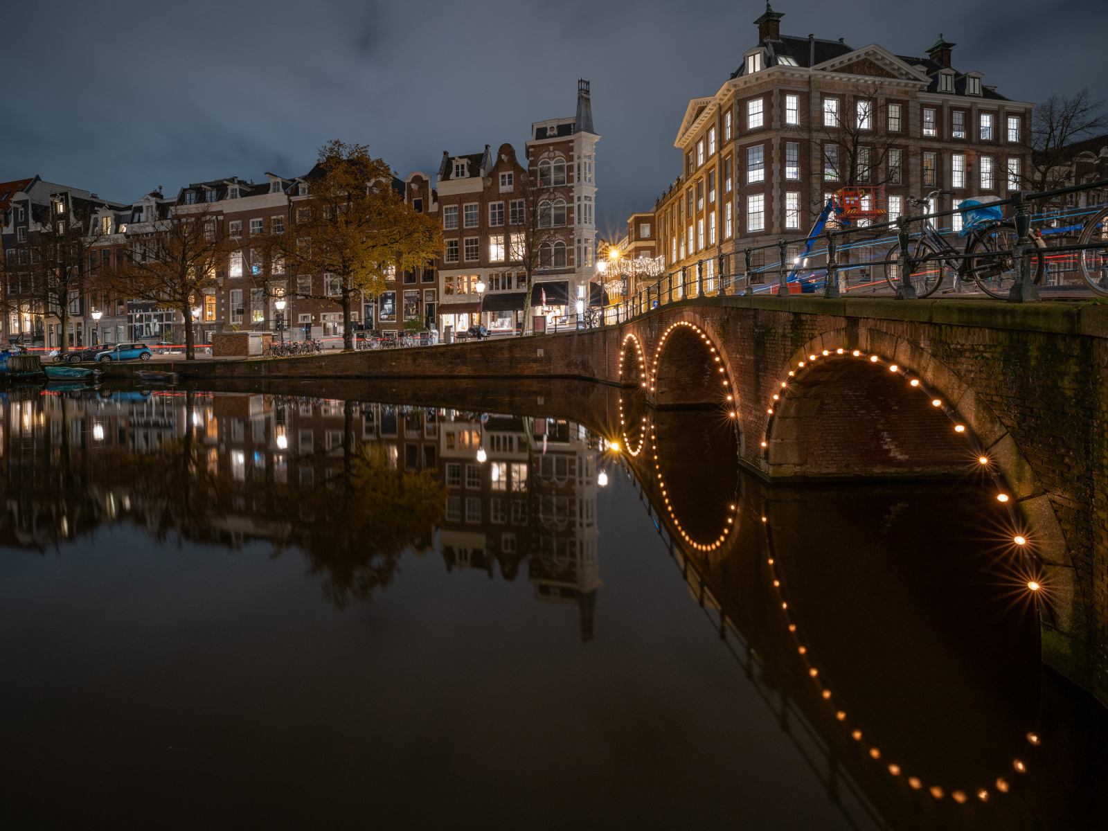 Водный канал в свете огней ночного города Амстердам, Нидерланды