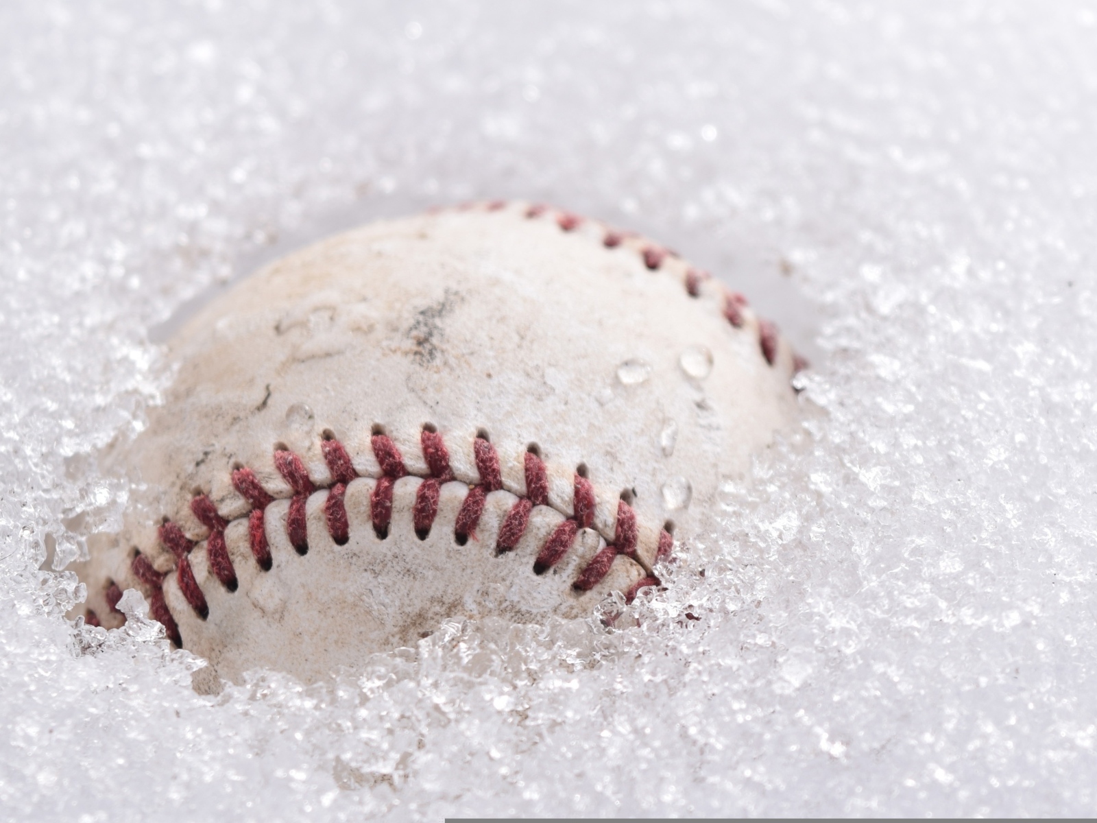 Бейсбольный мяч лежит в белом снегу