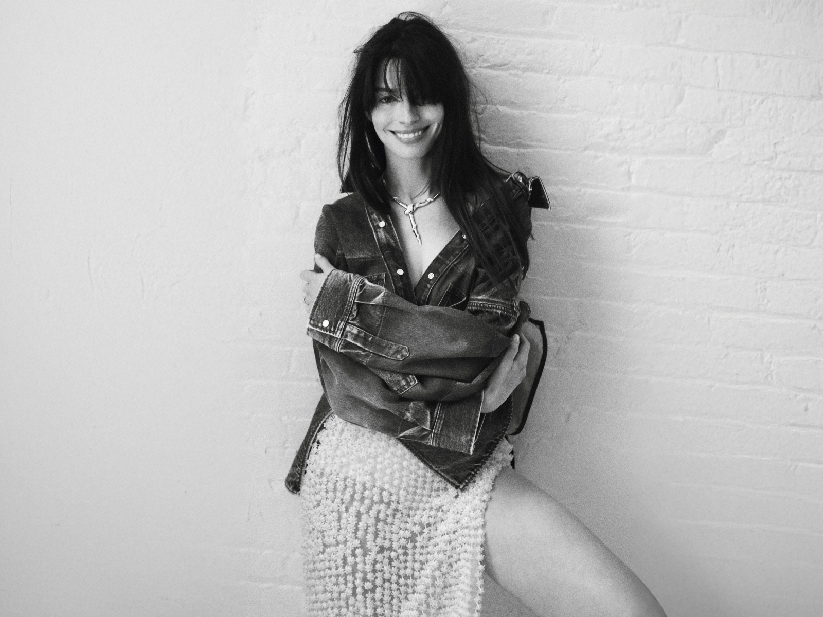 Актриса Энн Хэтэуэй стоит у стены черно-белое фото