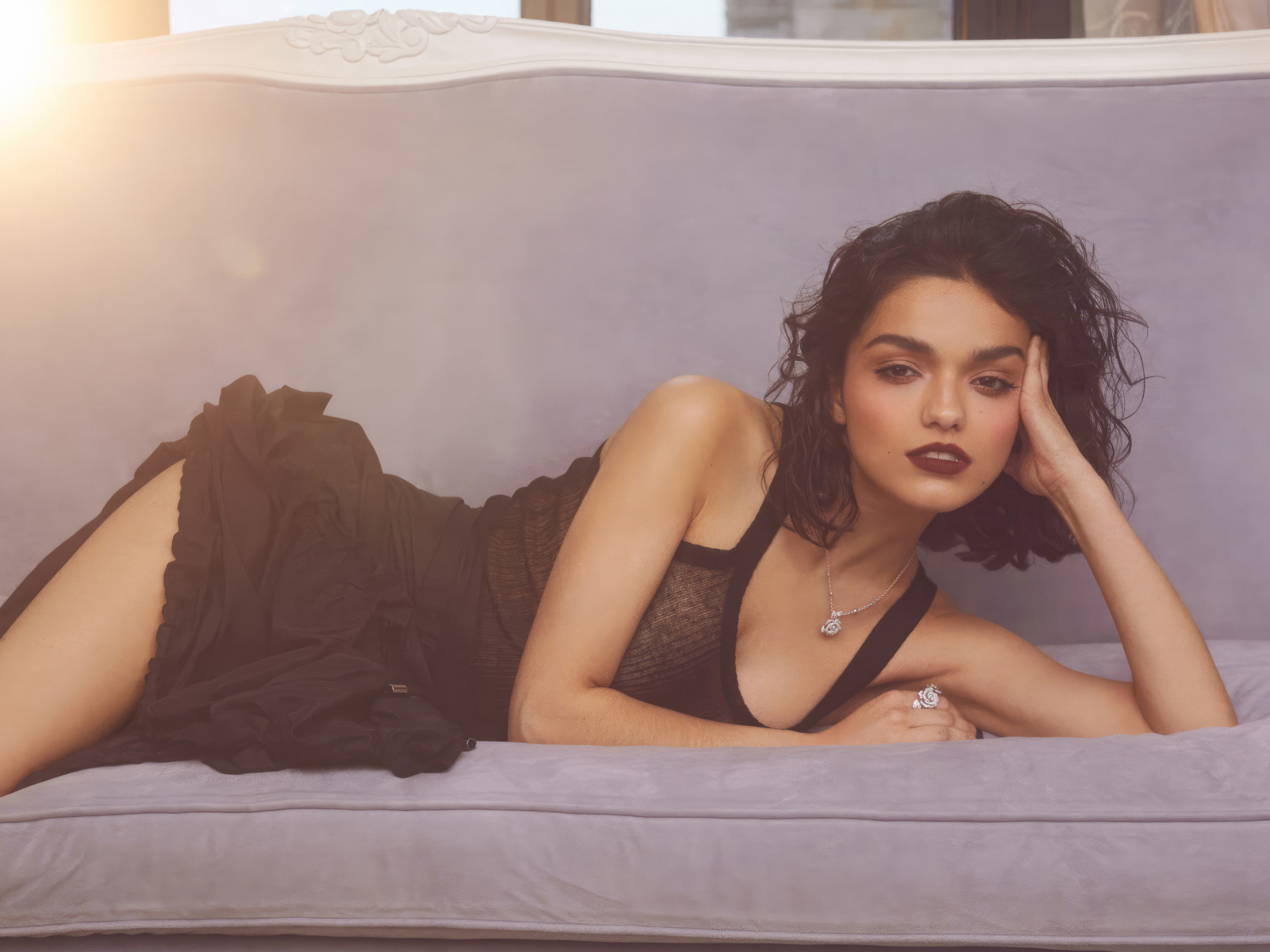 Актриса Рэйчел Зеглер в черном платье лежит на диване