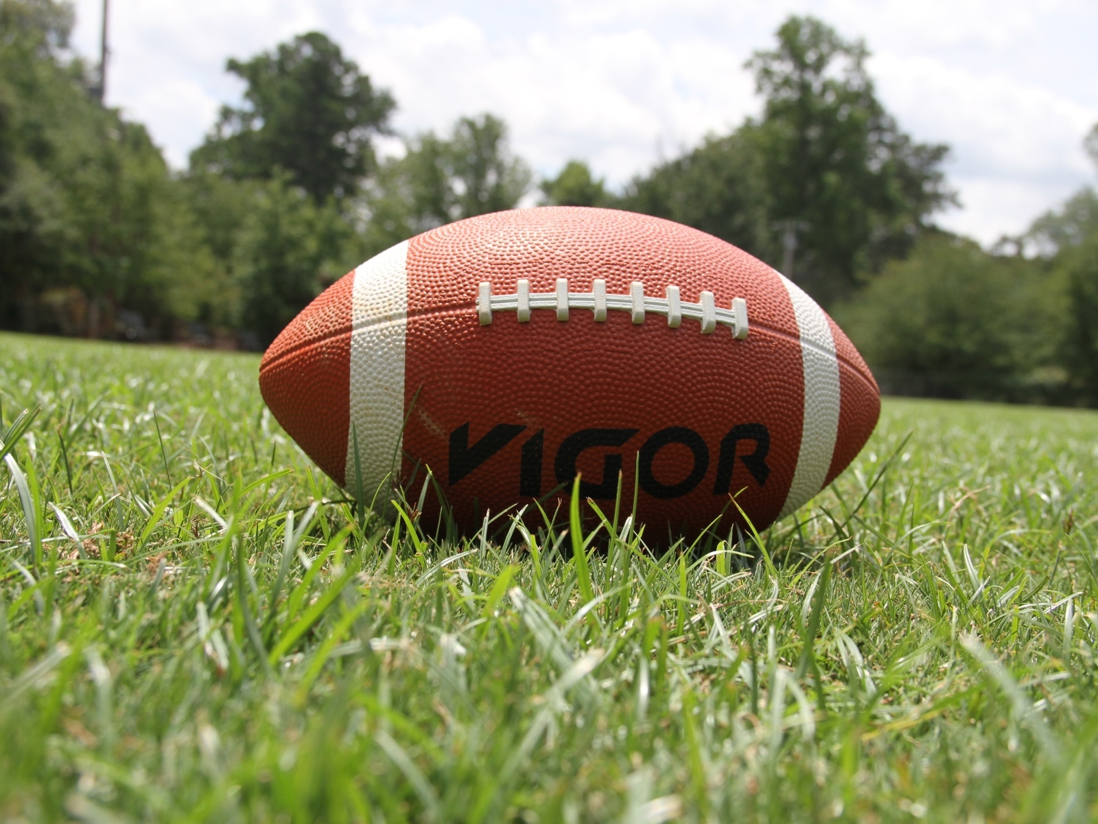 Мяч для американского футбола на зеленой траве 