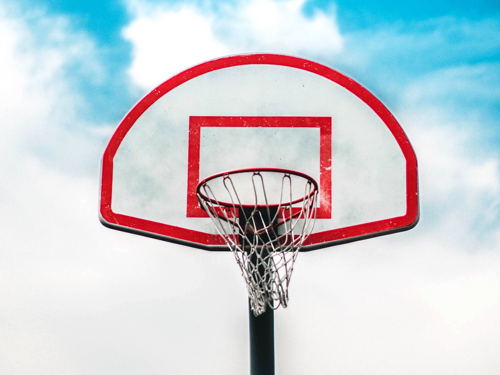 Баскетбольное кольцо на фоне белых облаков