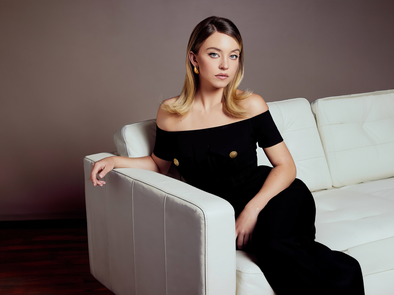 Милая девушка Сидни Суини в черном платье на диване