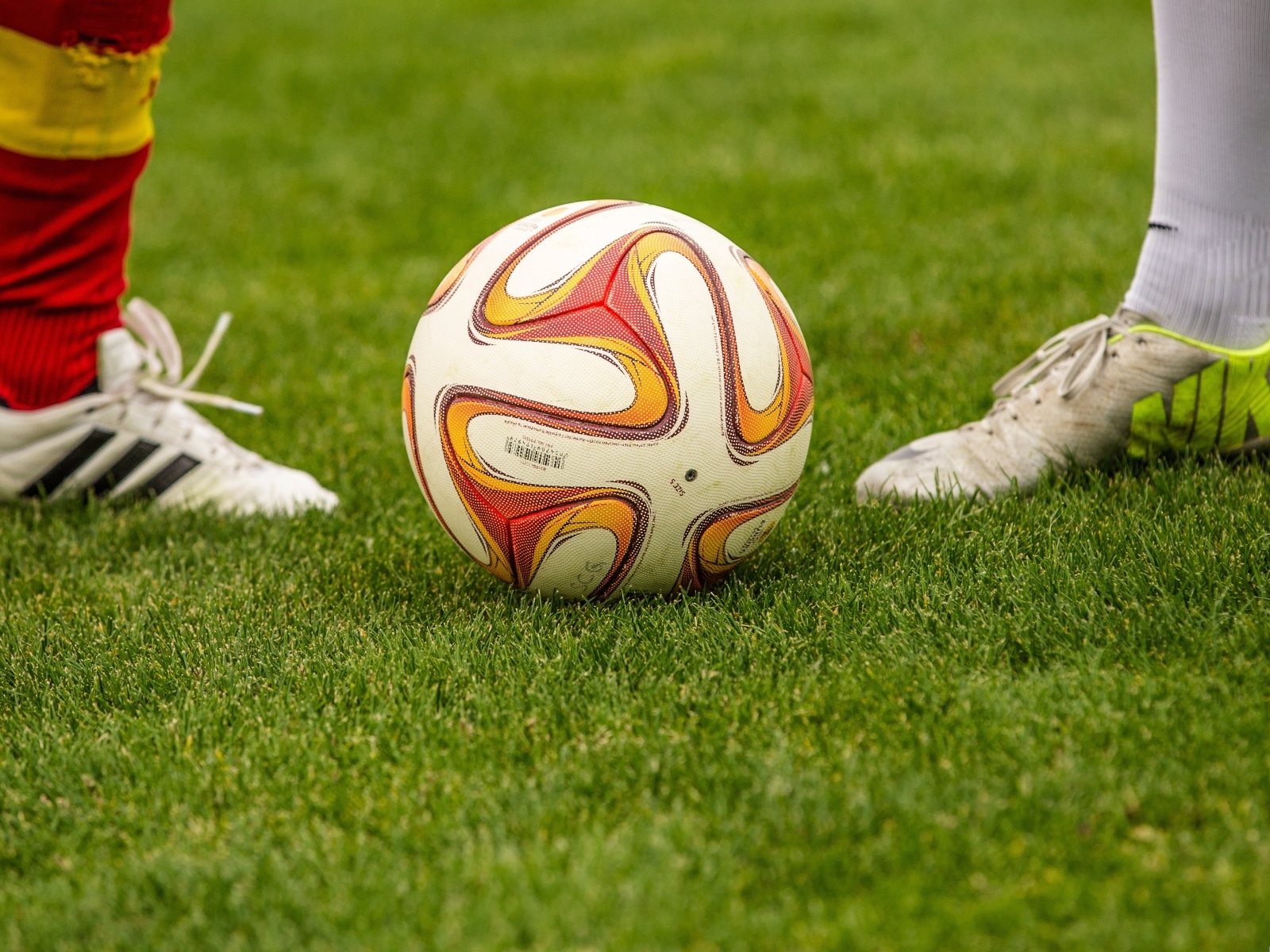 Футболисты с мячом на зеленой траве