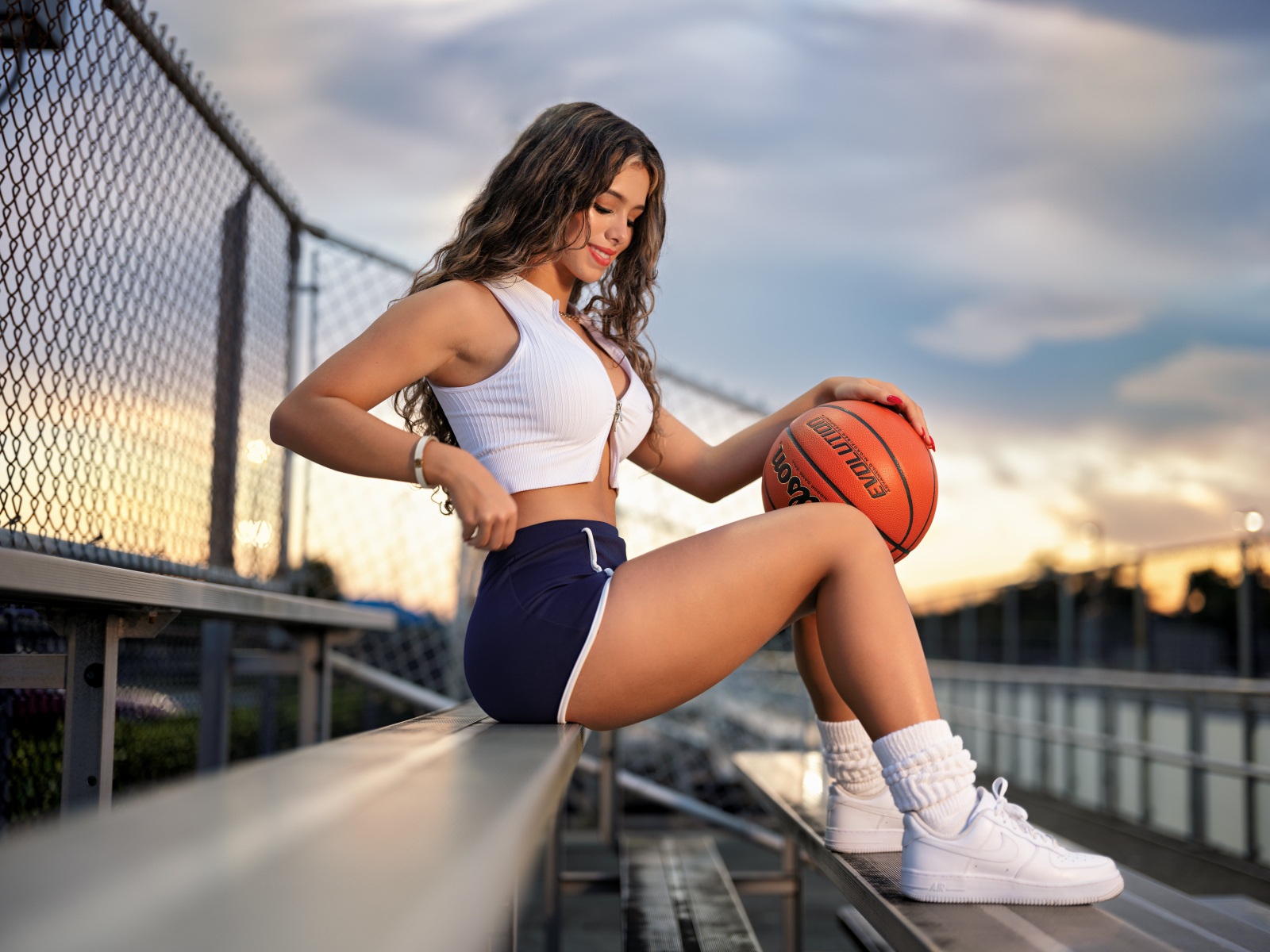 Улыбающаяся спортивная девушка с баскетбольным мячом