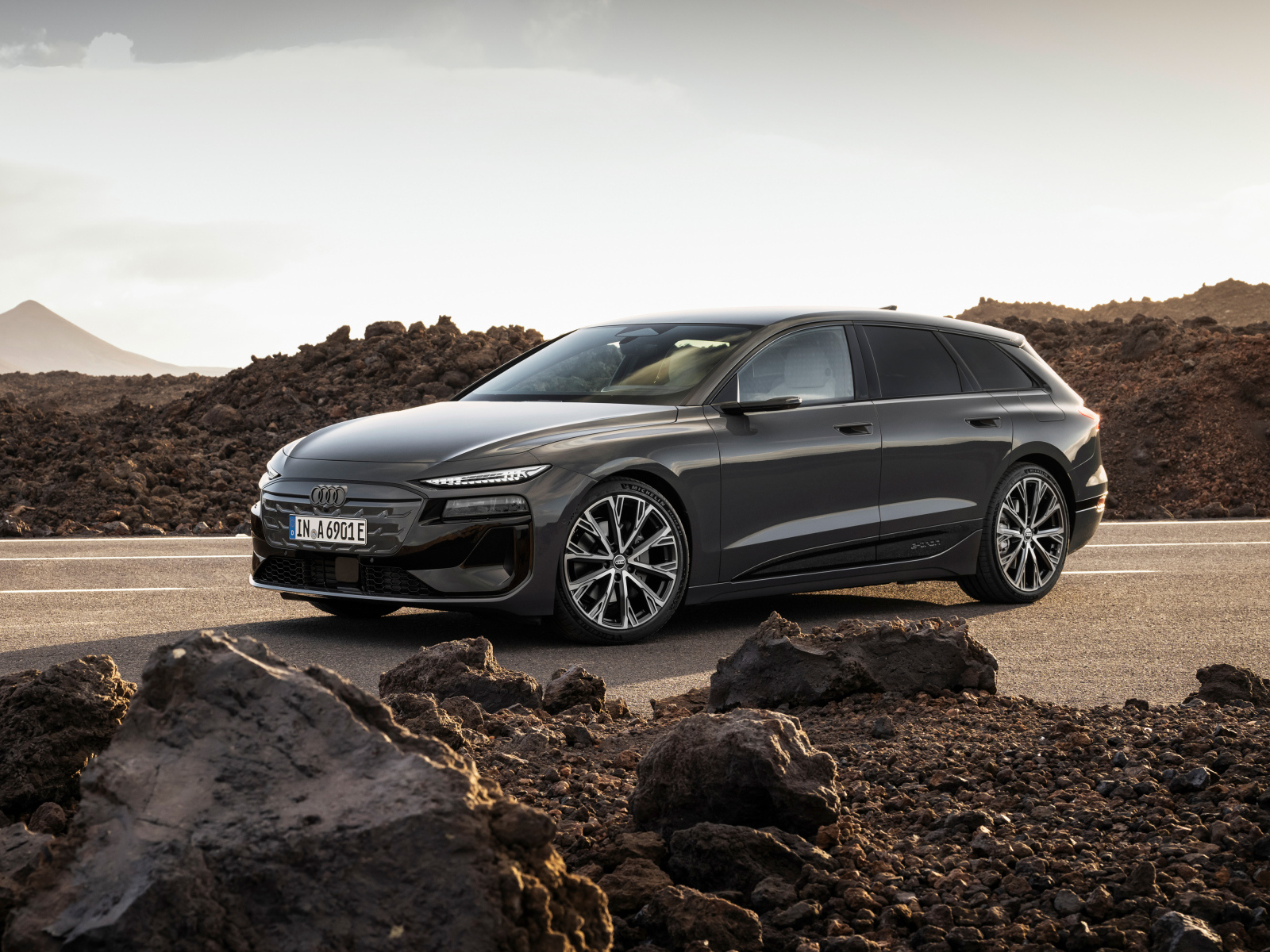 Автомобиль Audi A6 Avant e-tron S line 2024 года на дороге с камнями