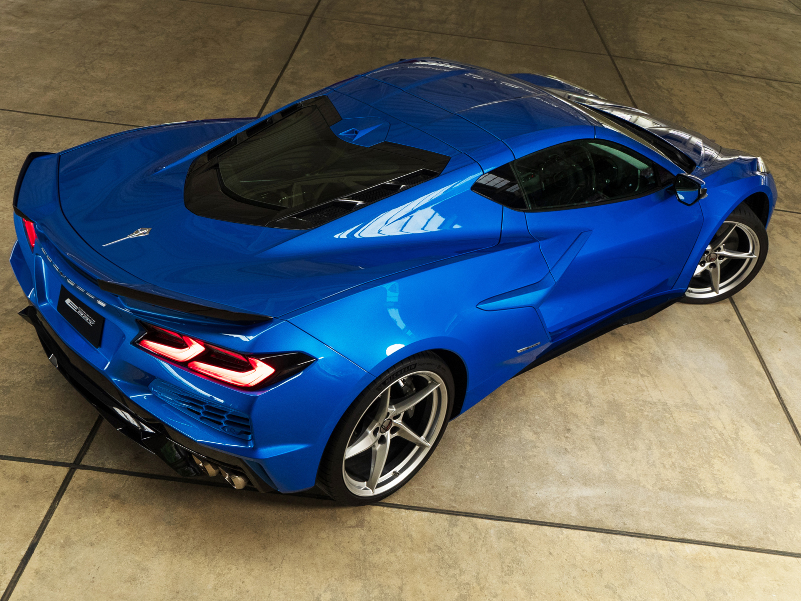 Вид сзади на синий автомобиль Chevrolet Corvette E-Ray 2024 года