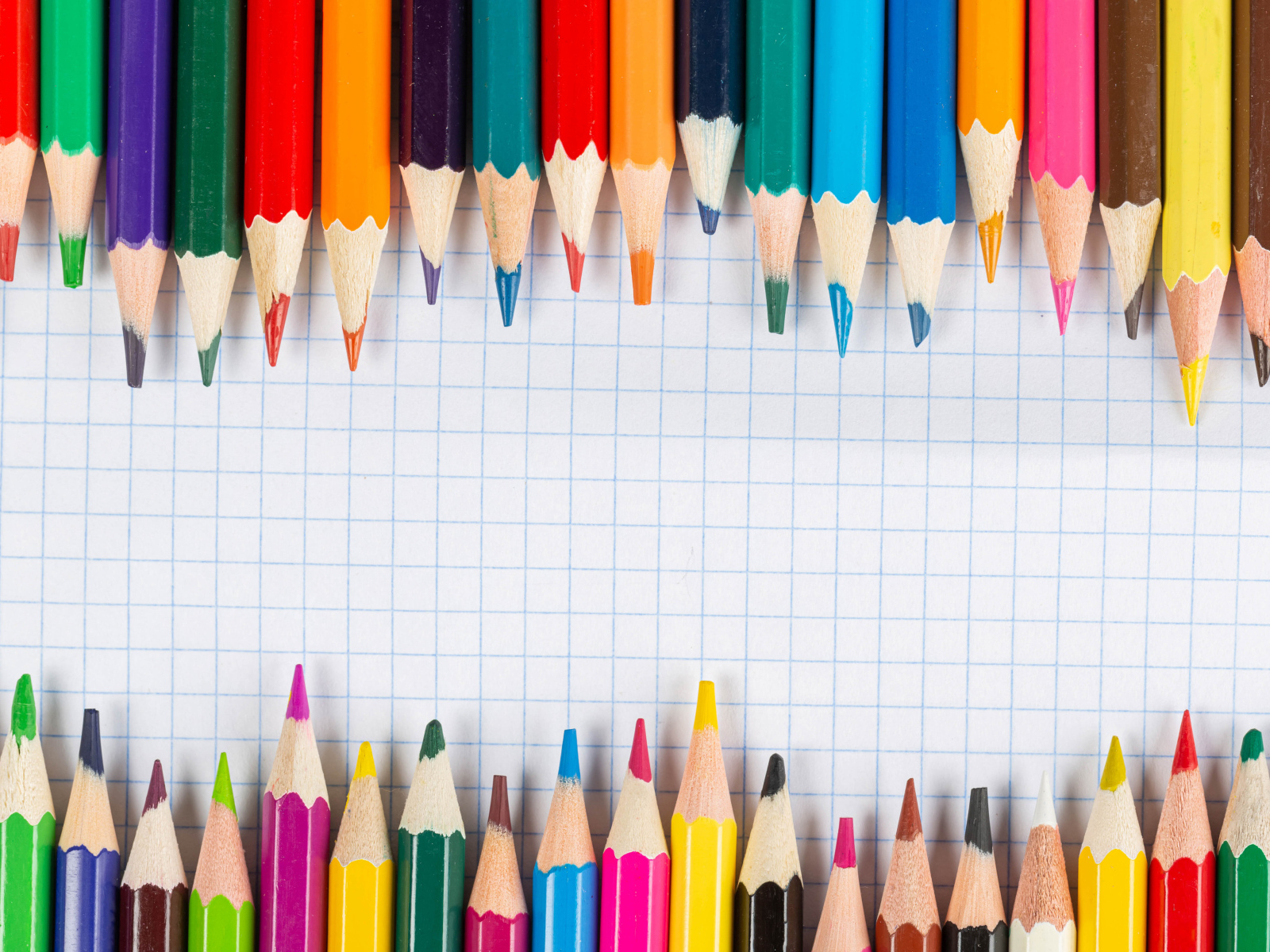 Заточенные карандаши на листе бумаги в клеточку