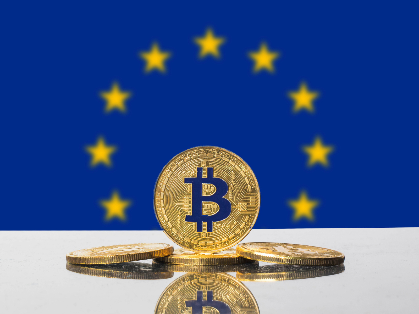 Монеты биткоин на фоне флага Евросоюза