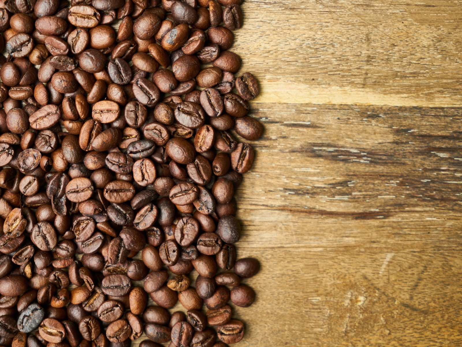 Ароматные жареные зерна кофе на деревянном столе