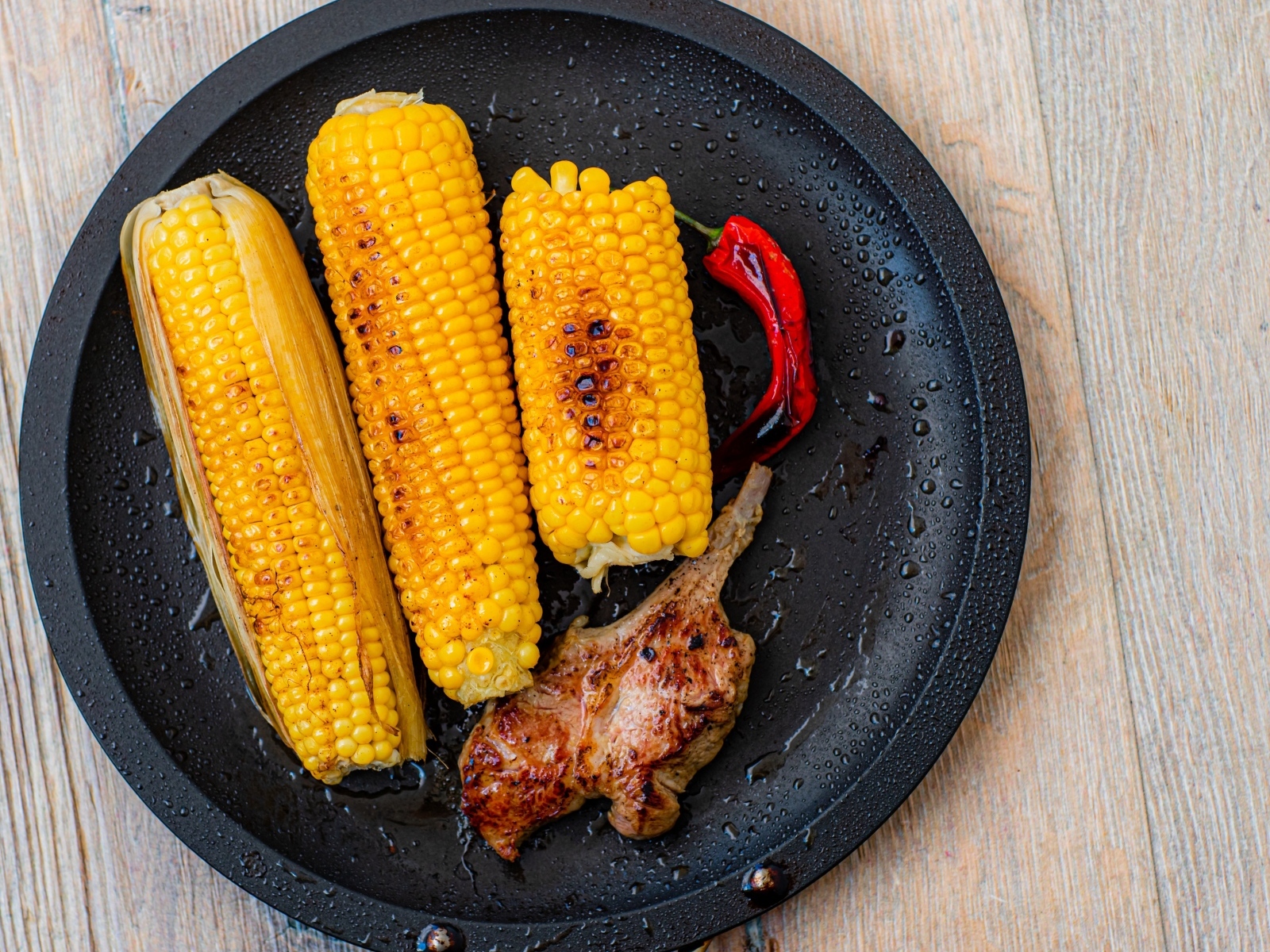 Запеченная кукуруза с ребрышками на тарелке