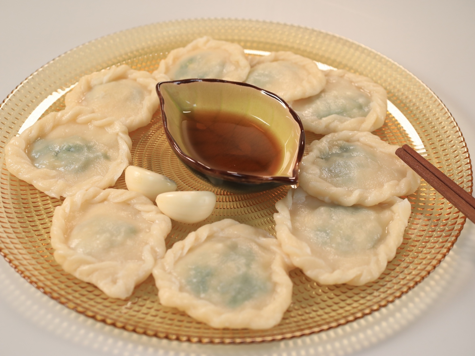 Блюдо дамплинг с соусом и чесноком на тарелке