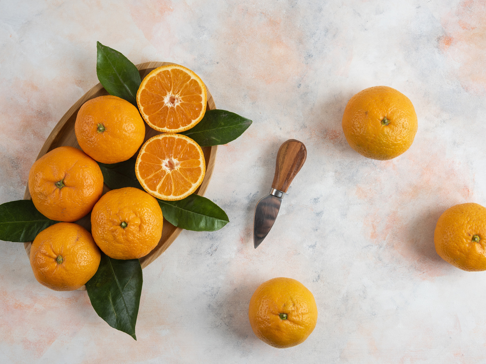 Крупные апельсины на столе с ножом