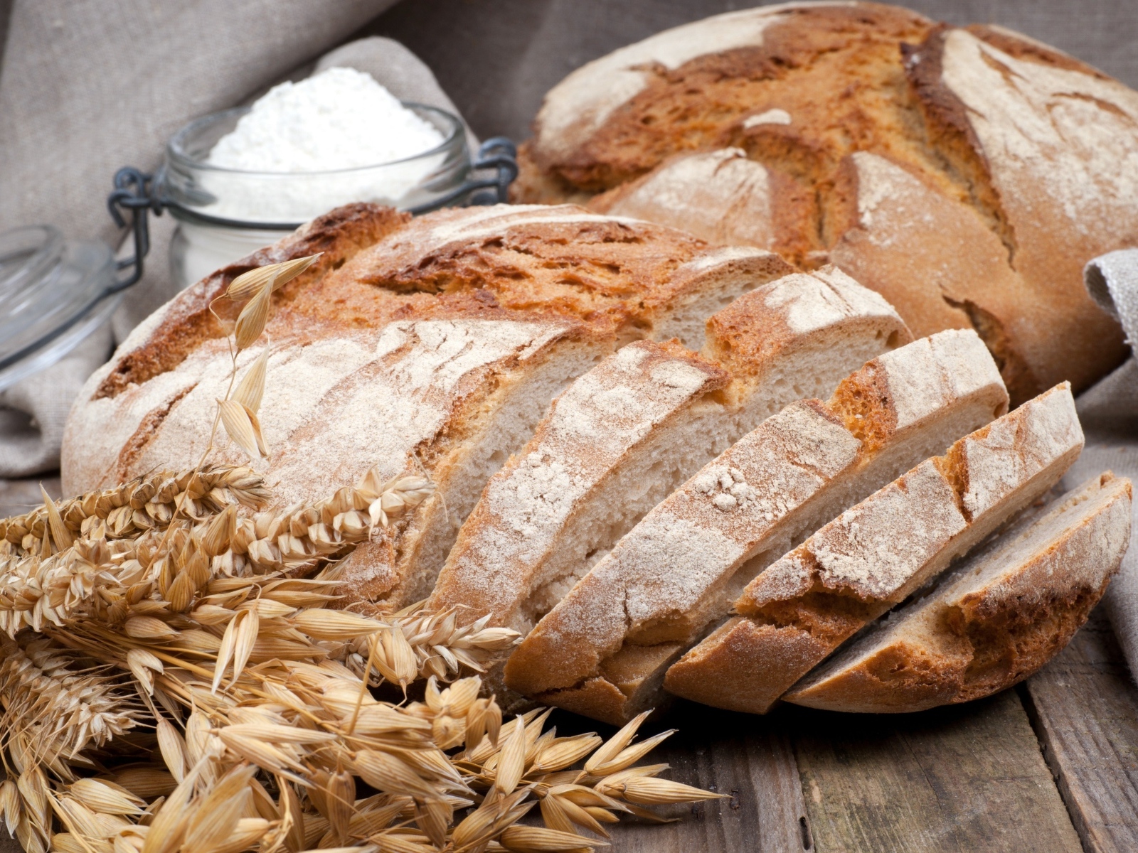 Нарезанный ржаной хлеб с колосьями на столе