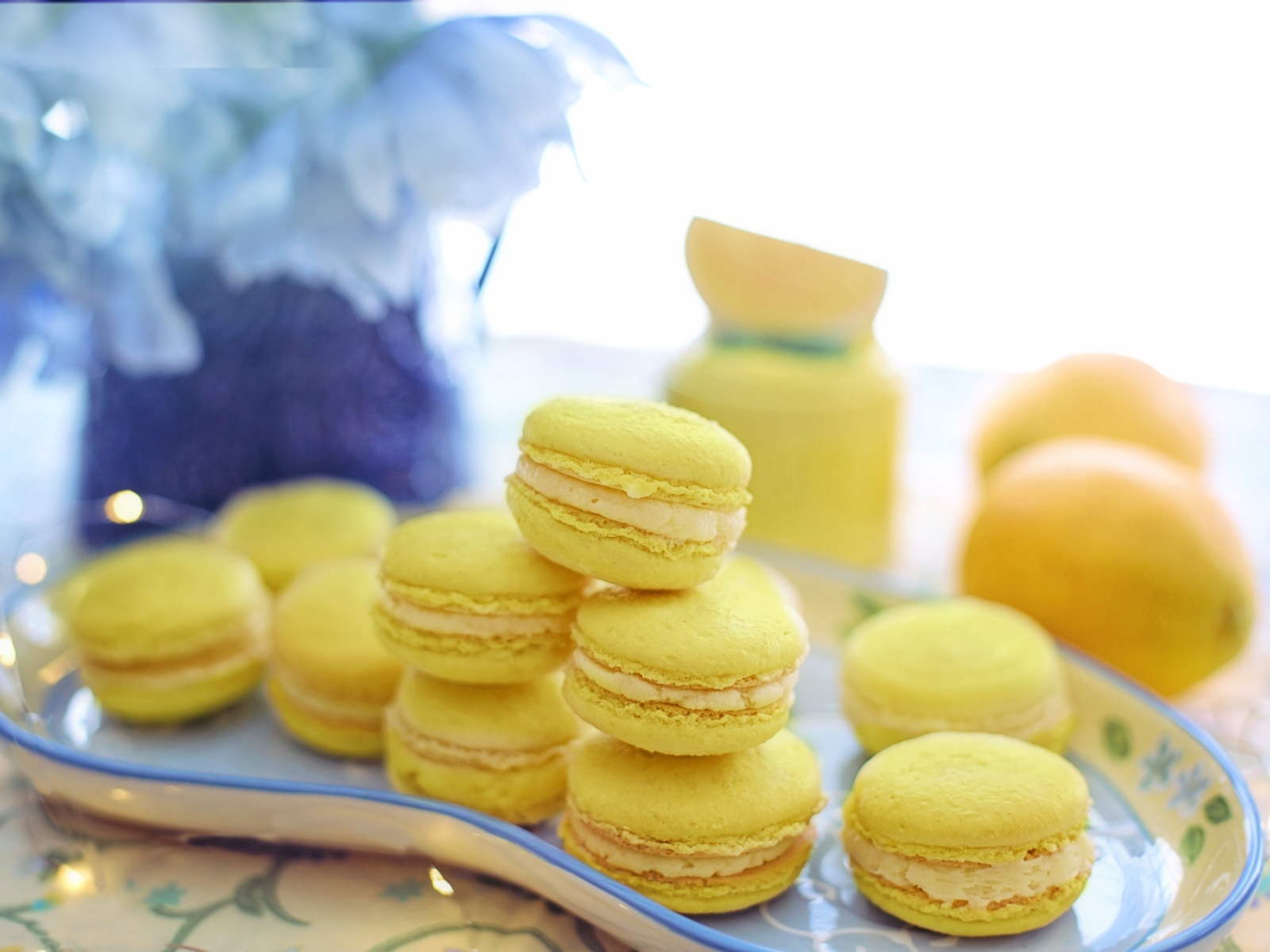 Десерт макарунс желтого цвета на тарелке на столе