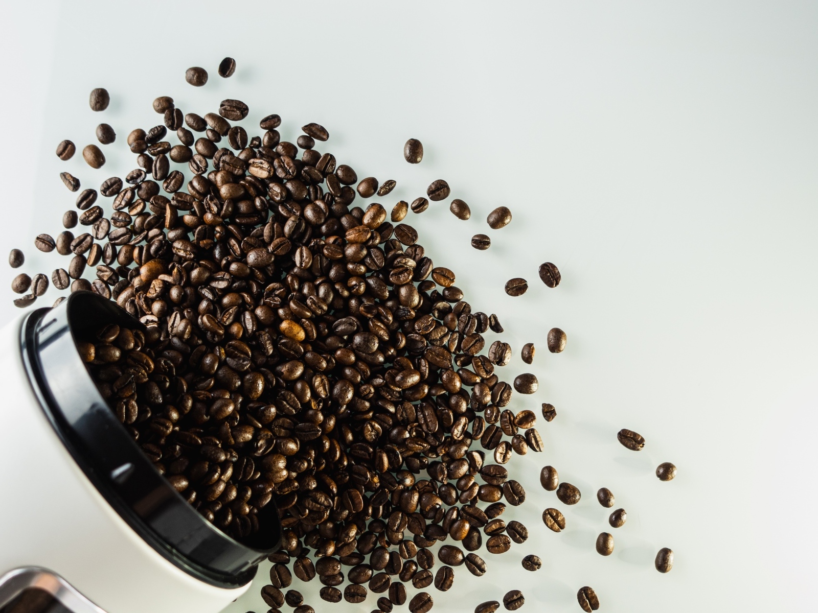 Много кофейных зерен на сером столе