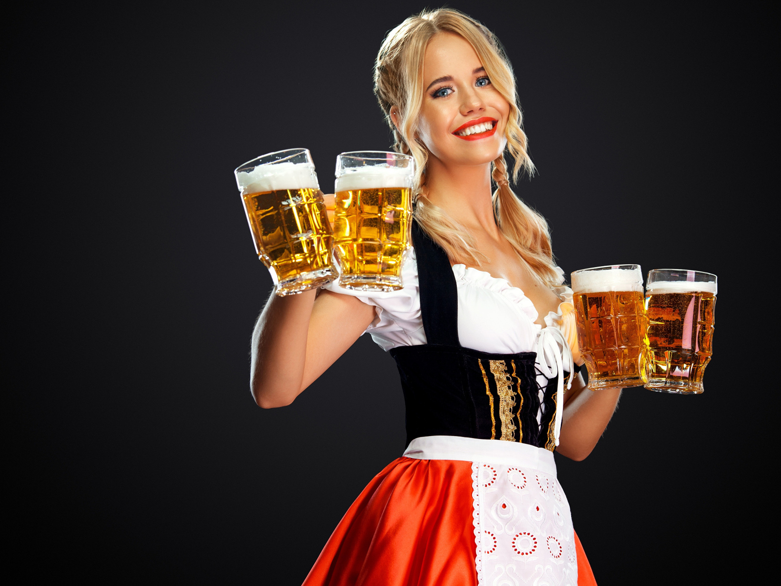 Красивая блондинка немка с бокалами пива на фестивале