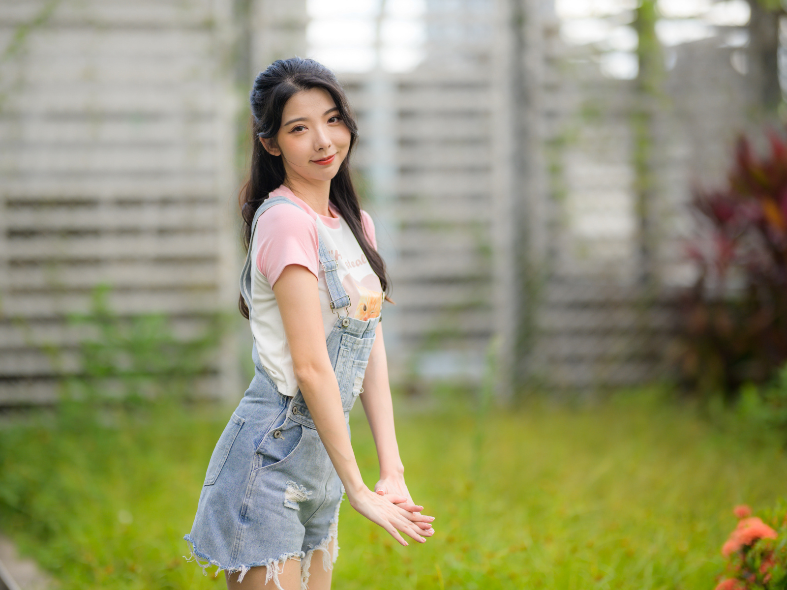 Милая девушка азиатка в джинсовом комбинезоне