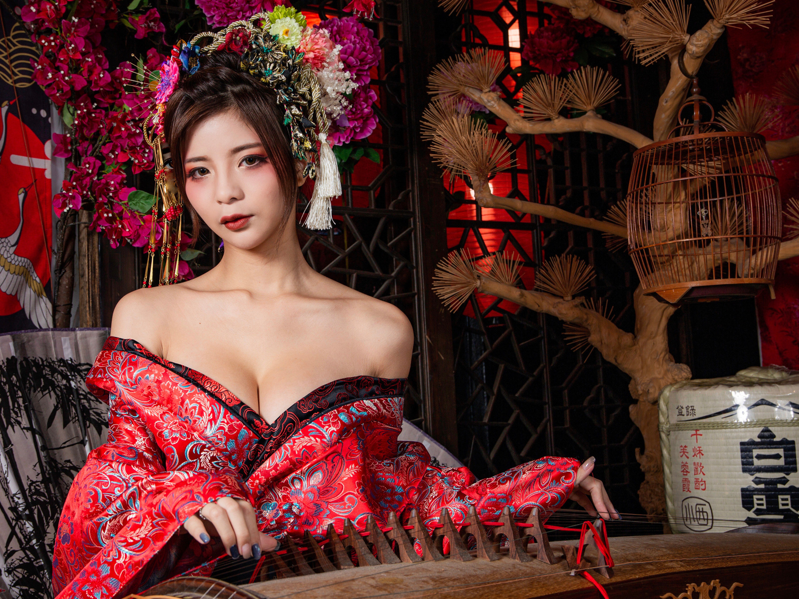 Милая девушка азиатка в красном кимоно с инструментом в руках