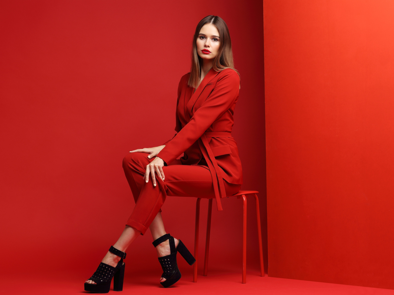 Девушка в красном костюме и черной обуви