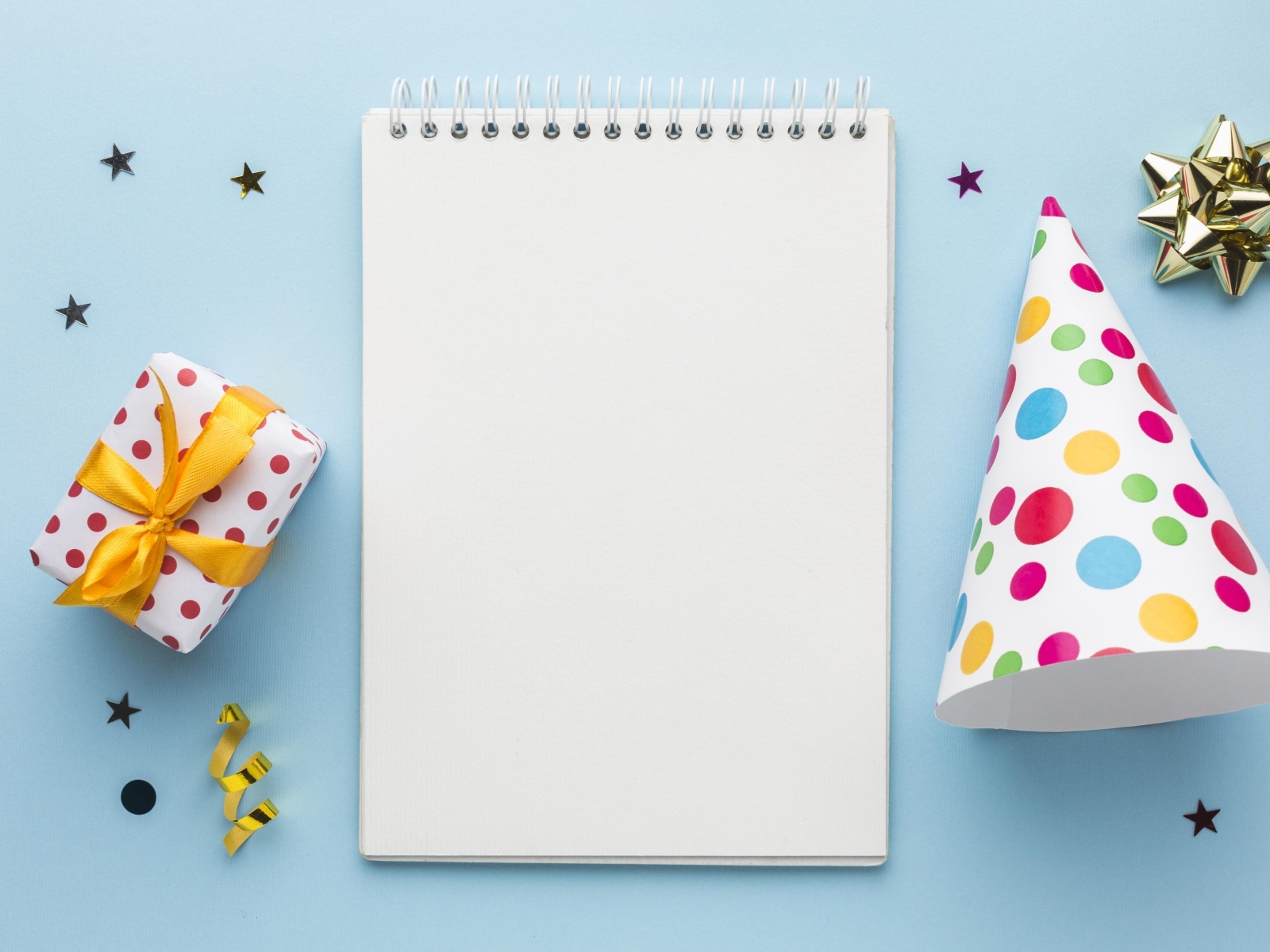 Подарок и колпак с блокнотом на голубом фоне, шаблон открытки