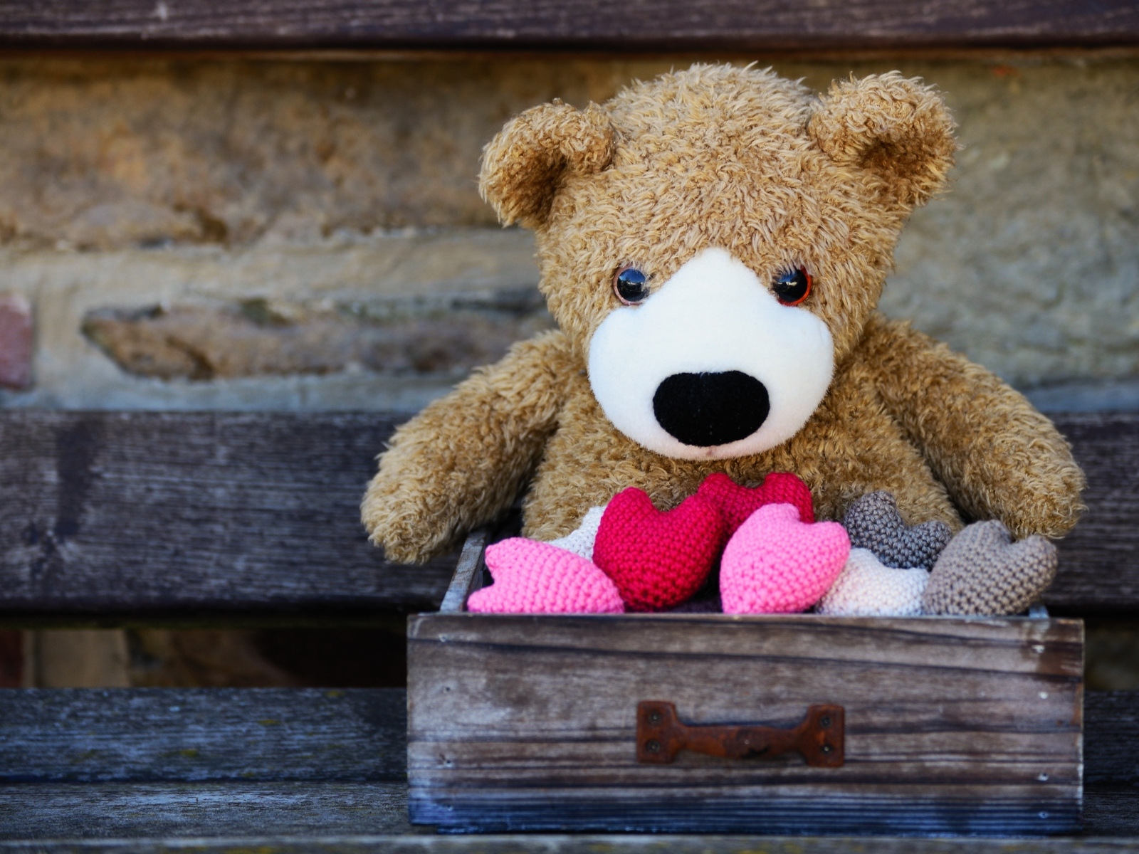 Игрушечный медвежонок с сердечками в деревянном ящике