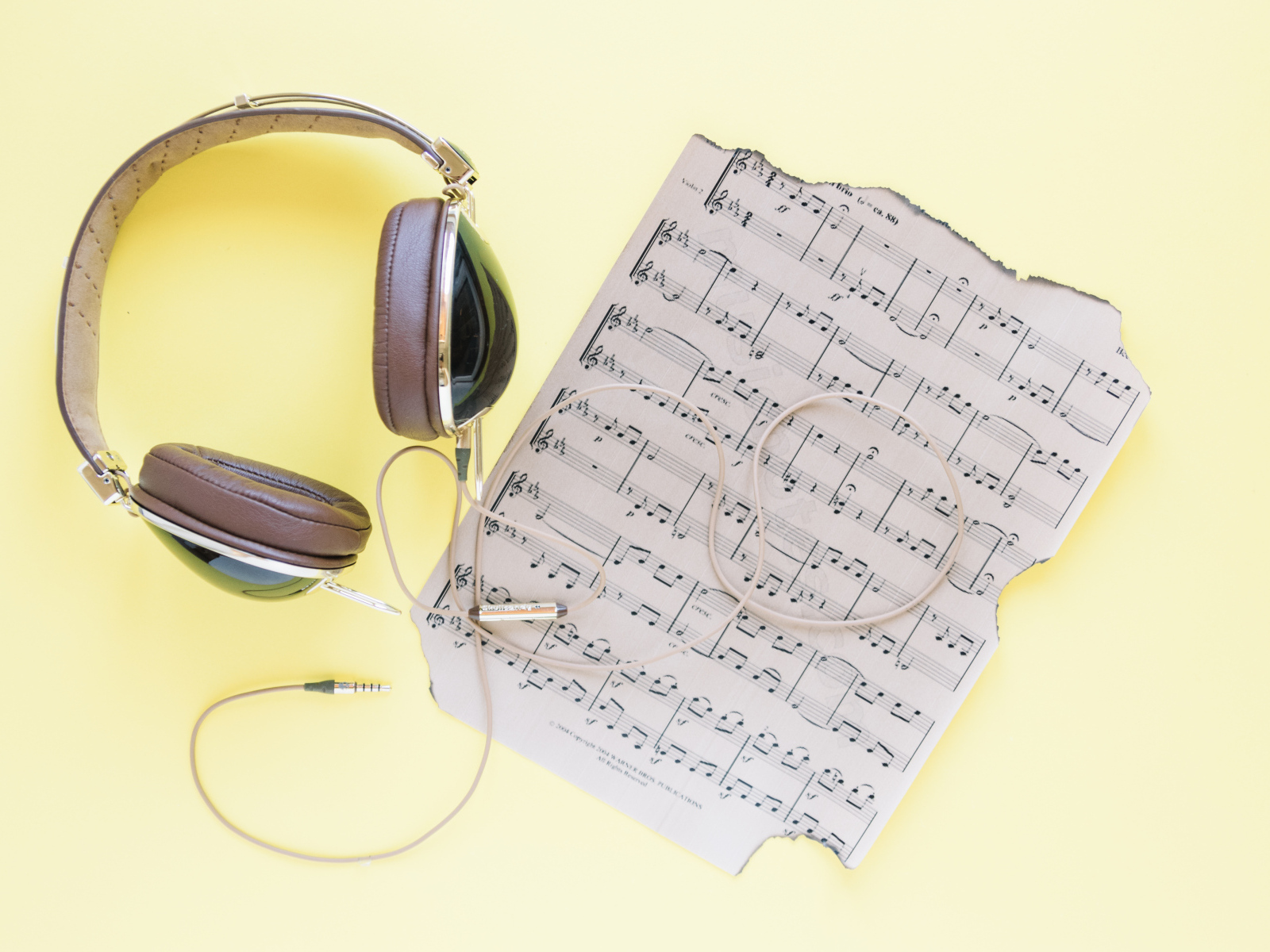 Старые ноты и наушники на желтом фоне