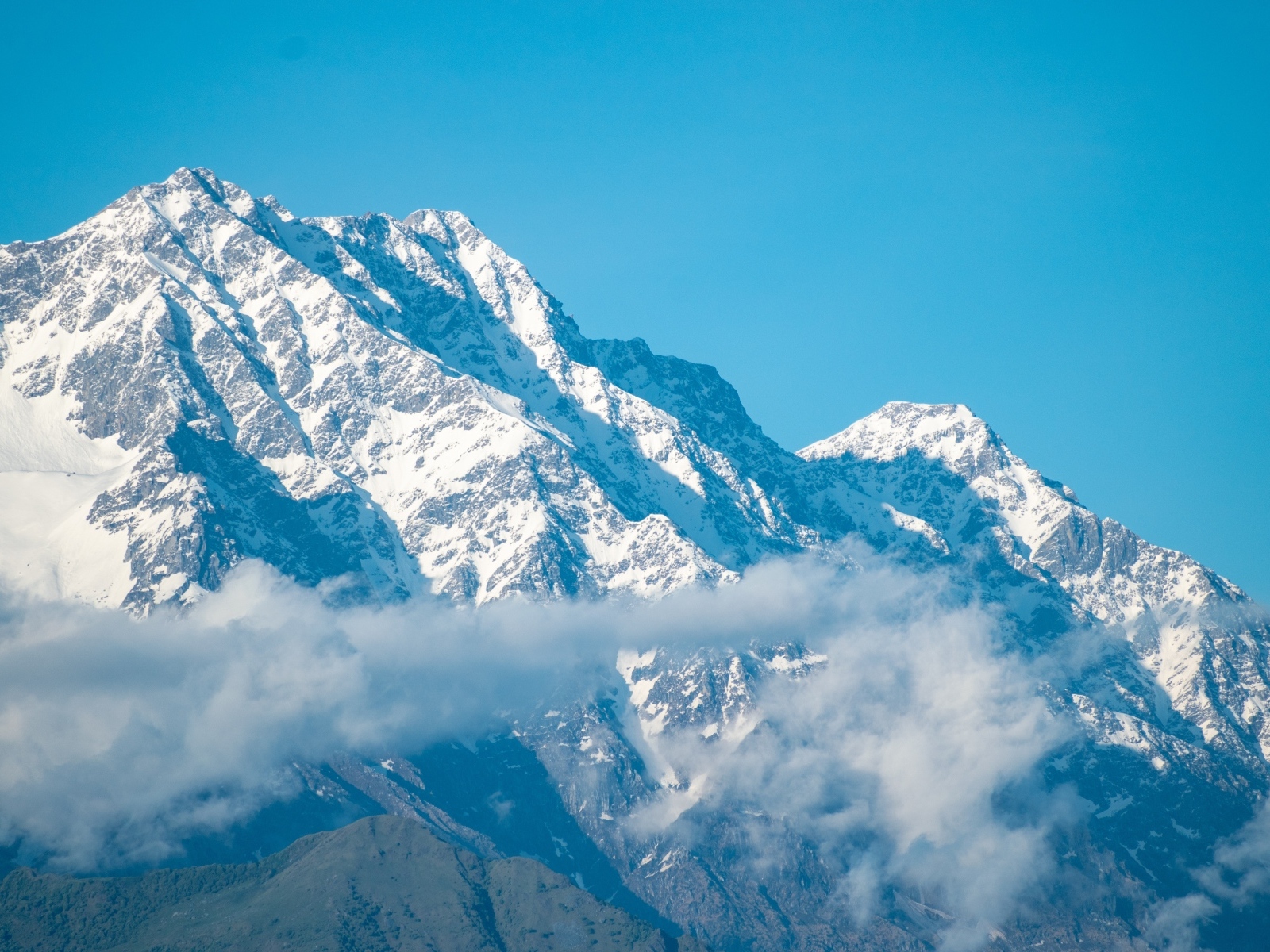 Высокие покрытые снегом горы на фоне голубого неба