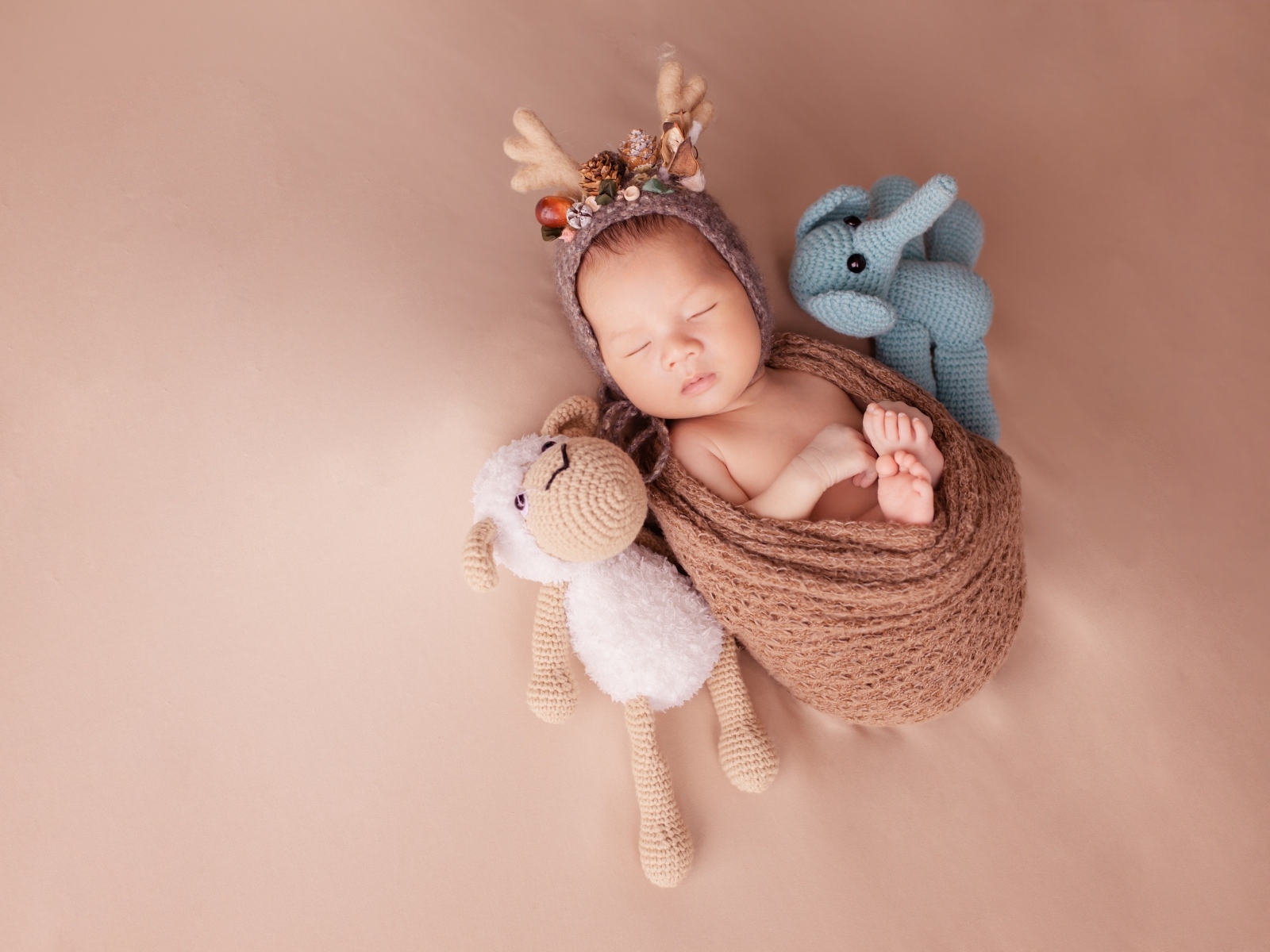 Маленький ребенок в костюме оленя с игрушкой