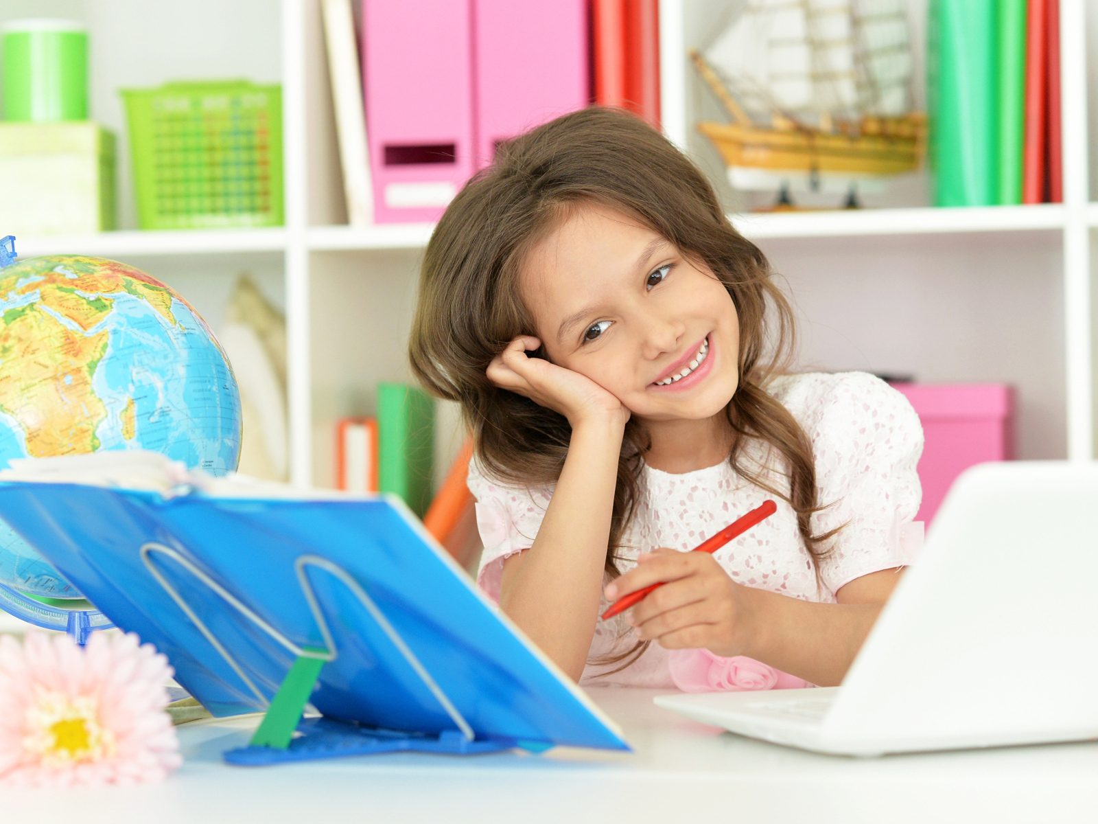 Улыбающаяся школьница делает уроки