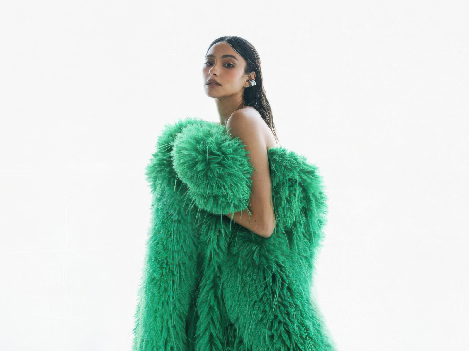 Актриса Шэй Митчелл в зеленой шубе на белом фоне