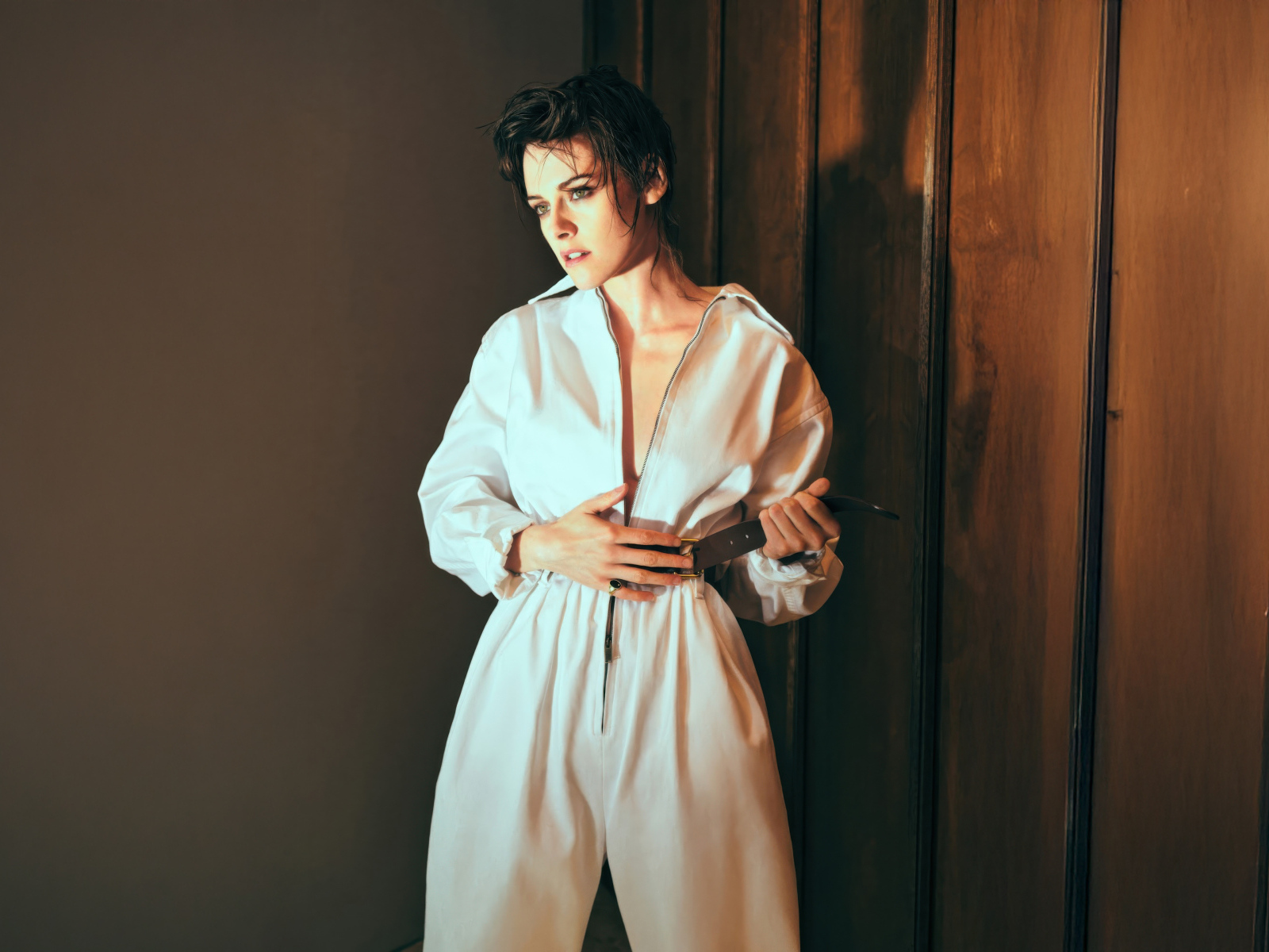 Американская актриса Кристен Стюарт в белом комбинезоне у стены
