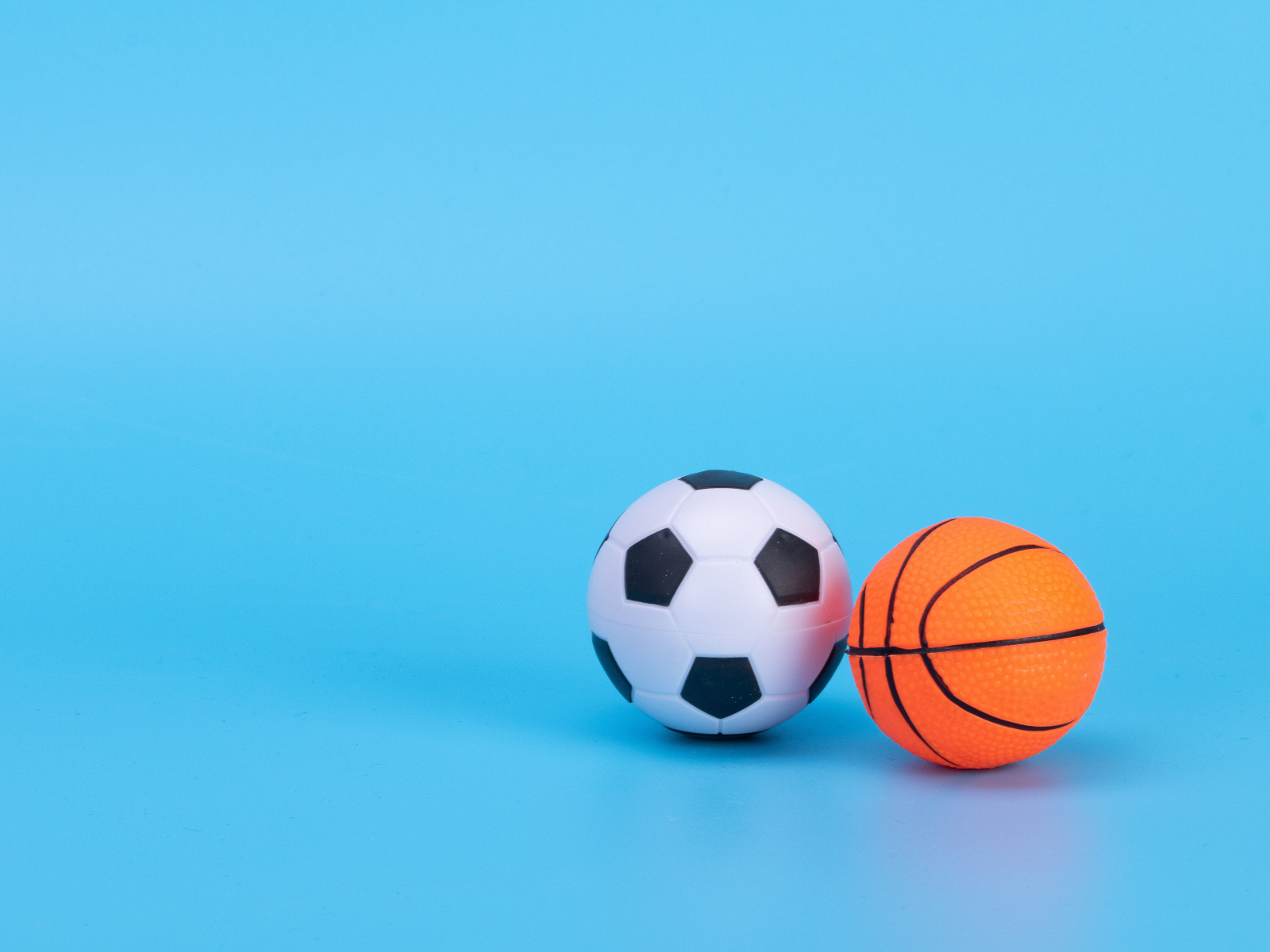 Футбольный и баскетбольный мяч на голубом фоне