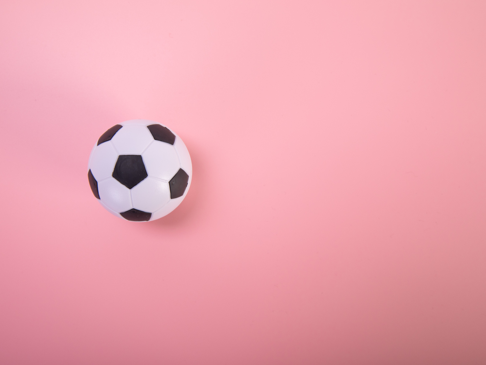 Футбольный мяч на розовом фоне