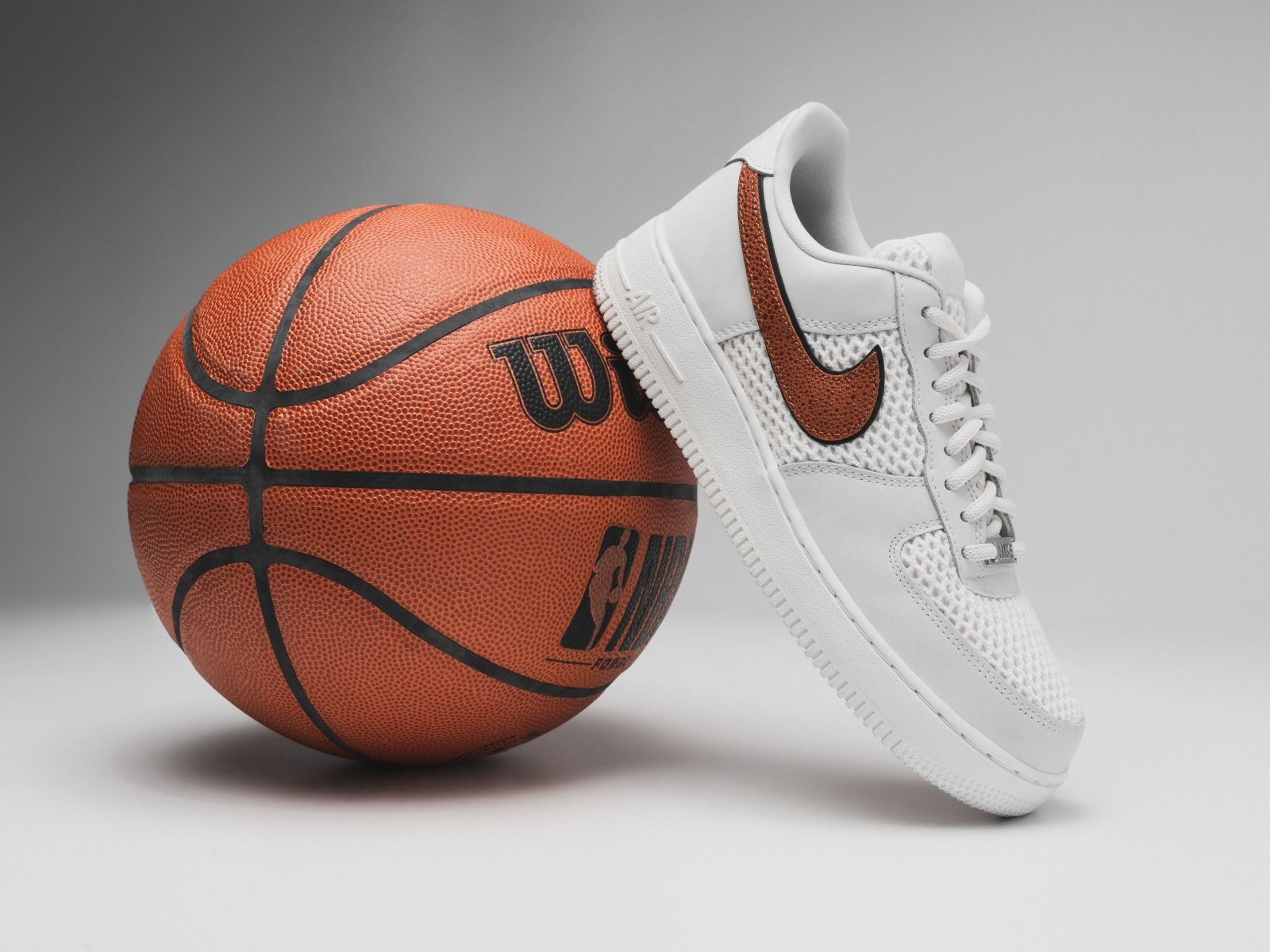 Спортивная обувь и баскетбольный мяч на сером фоне