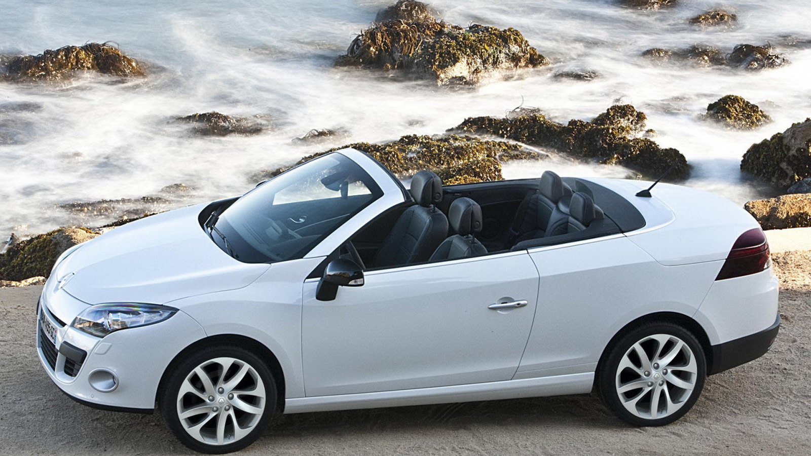 Рено Меган Купе Кабриолет двигаясь параллельно волнам