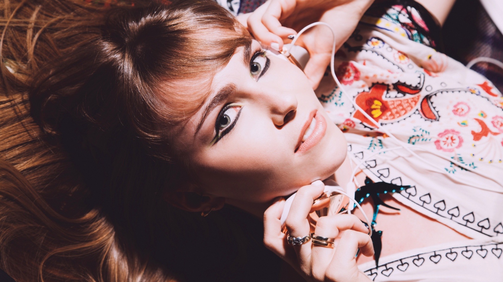 Девушка лежит с наушниками