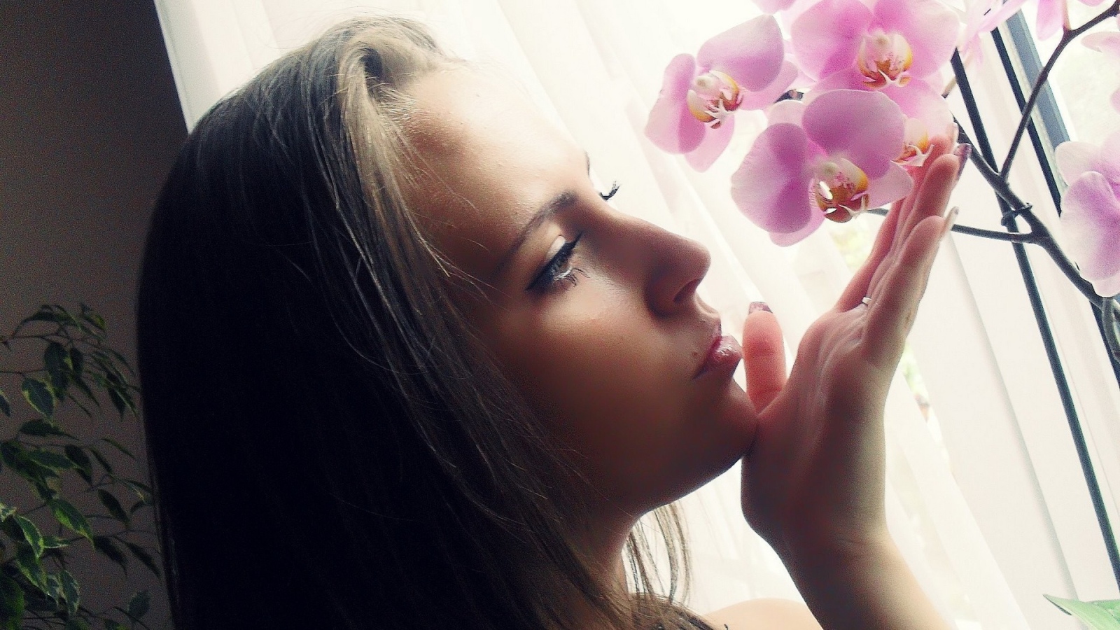 Девушка смотрит орхидею
