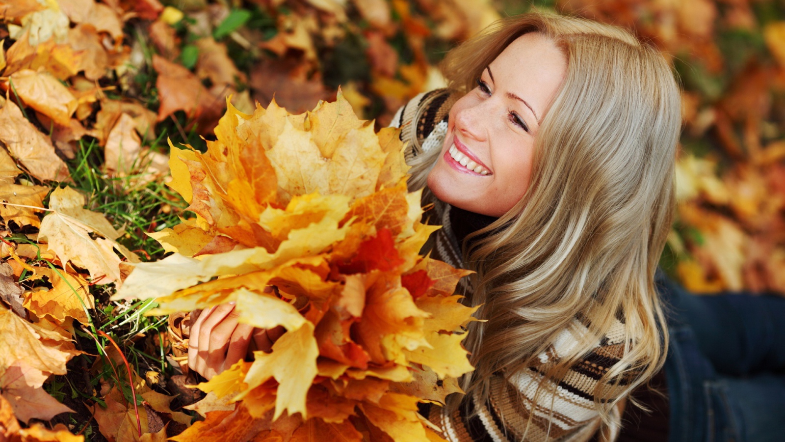 Красивая девушка держит осенние листья