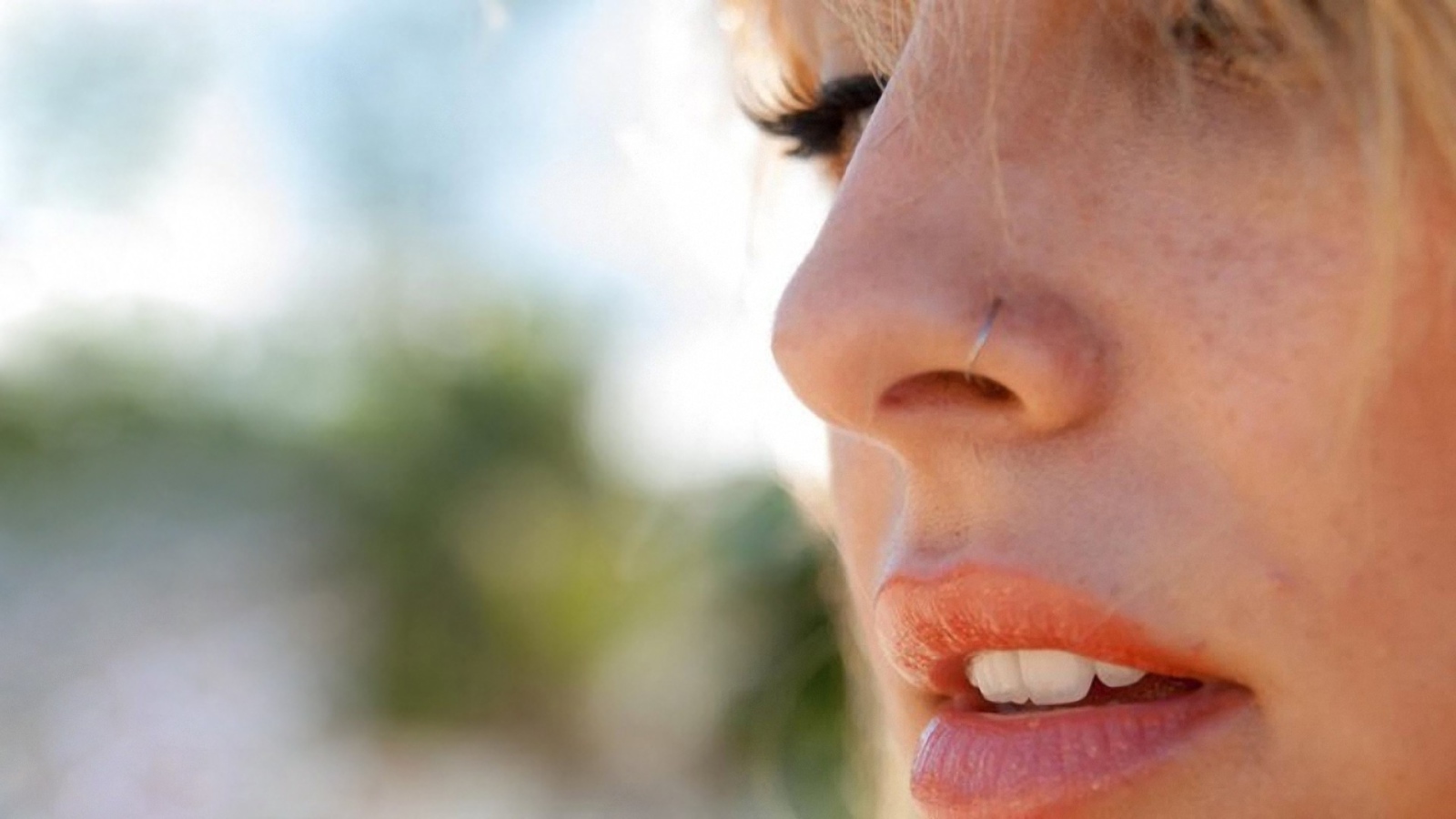 Девушка блондинка с пирсингом в носу крупным планом