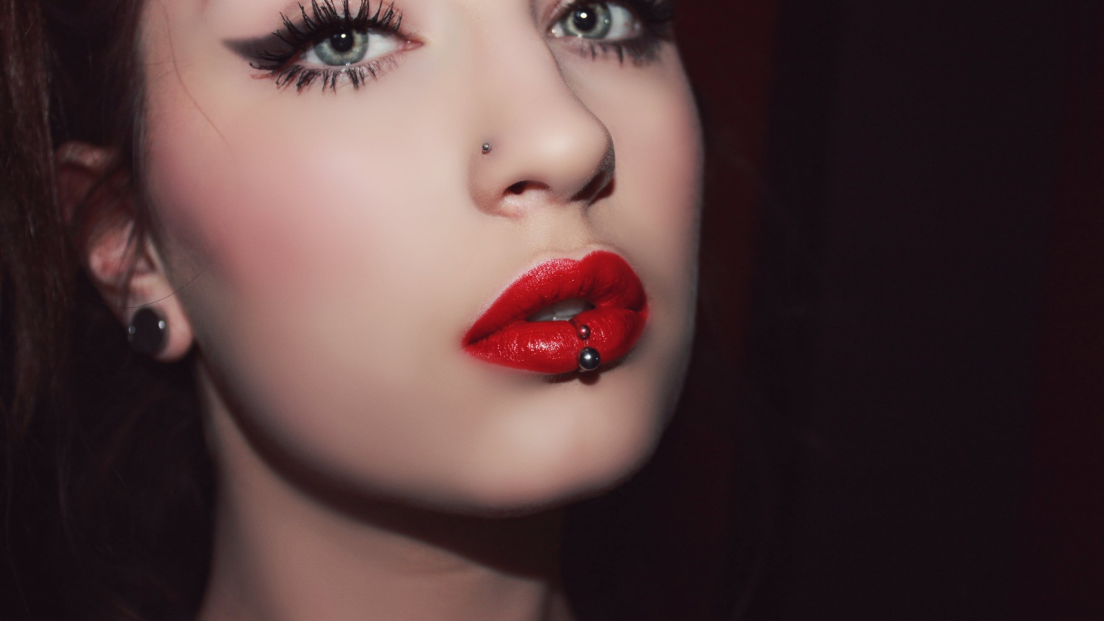 Девушка брюнетка с пирсингом в губе и носу