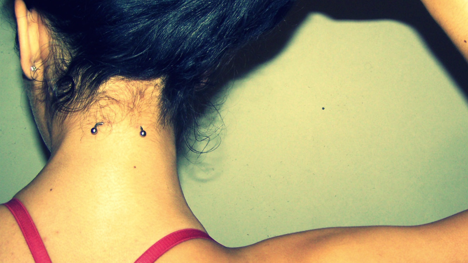 Девушка брюнетка с пирсингом в шее